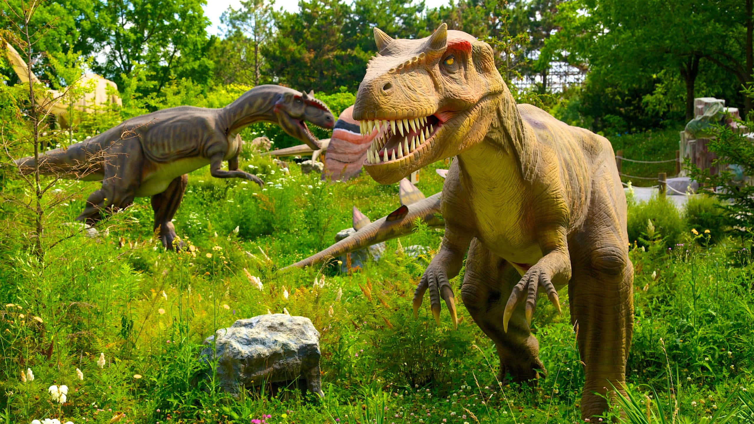 dinosaur exhibit vaughan, lifelike dinosaur statues, sunlit grassy park, 2K Desktop Wallpaper