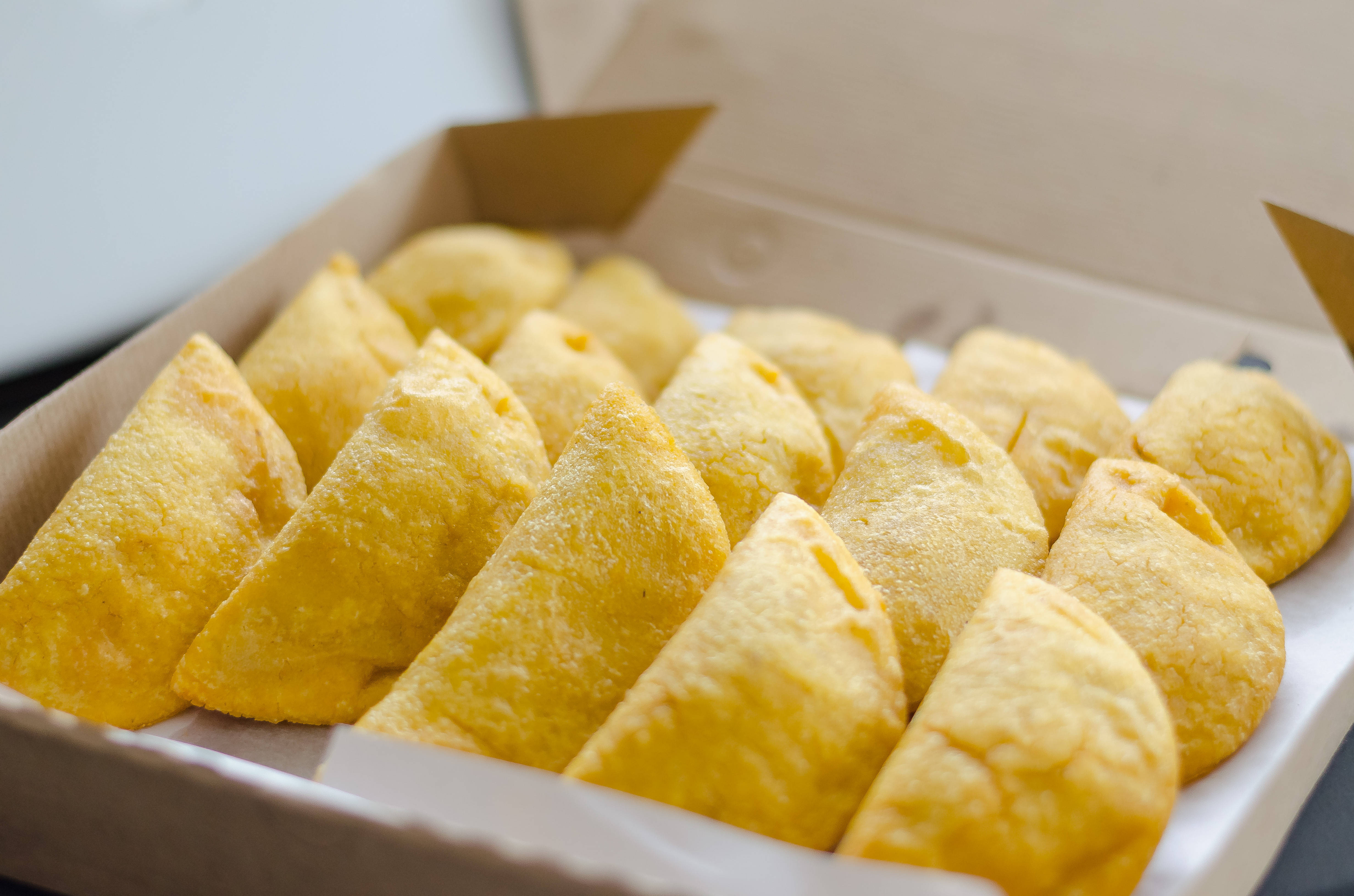 Venezuelan Delectable Empanadas, golden-brown triangular pastries, flaky texture, 4K Desktop Wallpaper