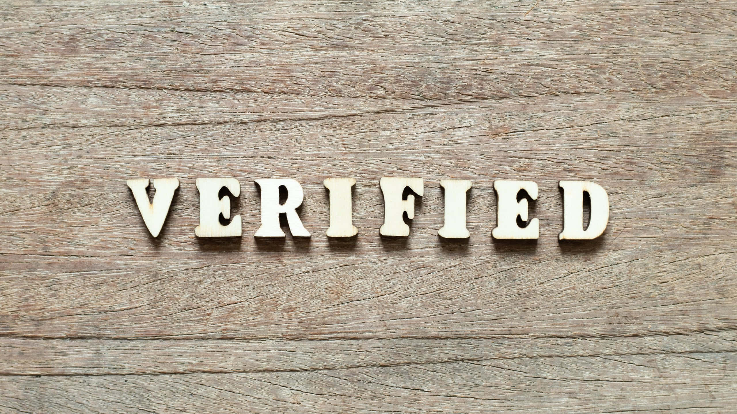 VERIFIED, white wooden letters, textured rustic wood surface, 2K Desktop Wallpaper