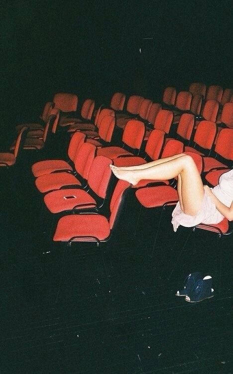 red theater seats, darkened auditorium, lone person, SD Phone Wallpaper