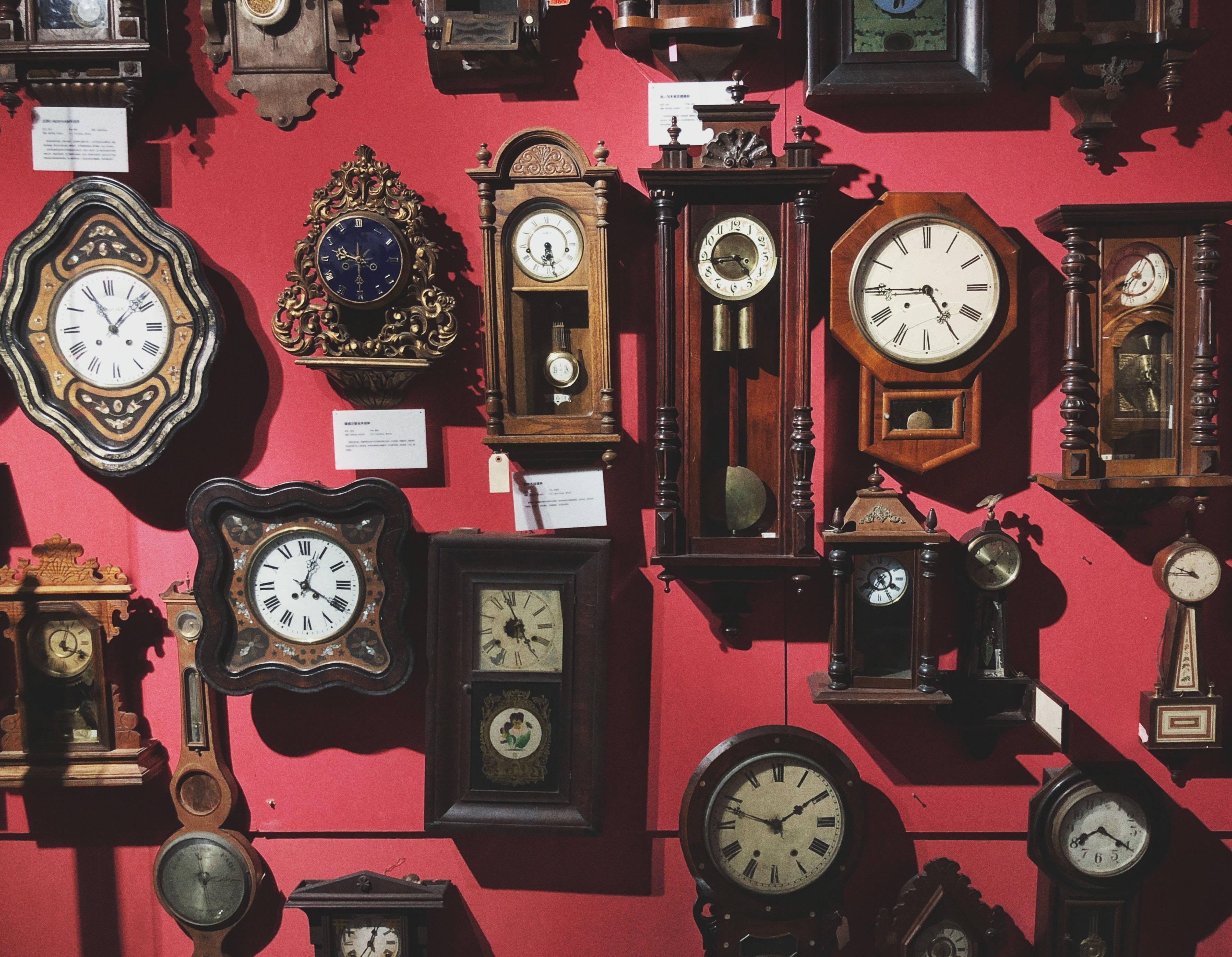 vintage wooden clocks, ornate frames, bold red wall, 2K Desktop Wallpaper