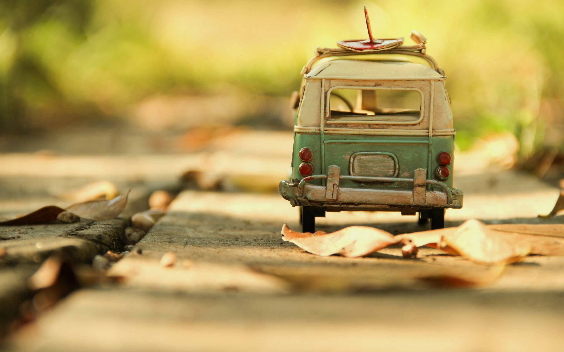 vintage green toy van, surfboard on roof, leaf-strewn path, Full HD Desktop Wallpaper