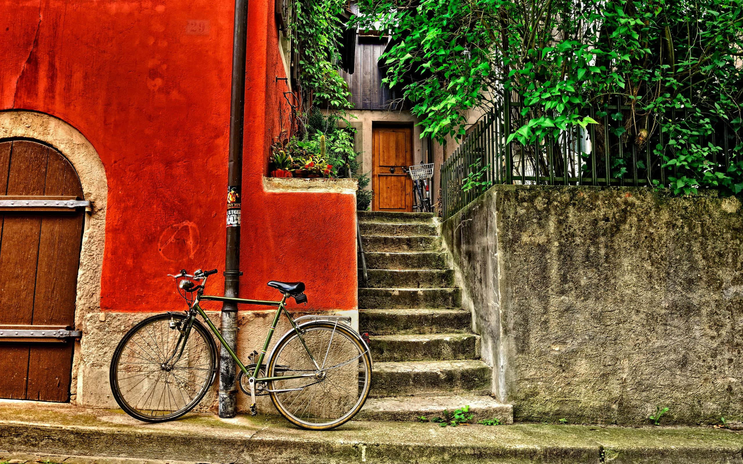 vintage green bicycle, vibrant red wall, stone stairs, 2K Desktop Wallpaper