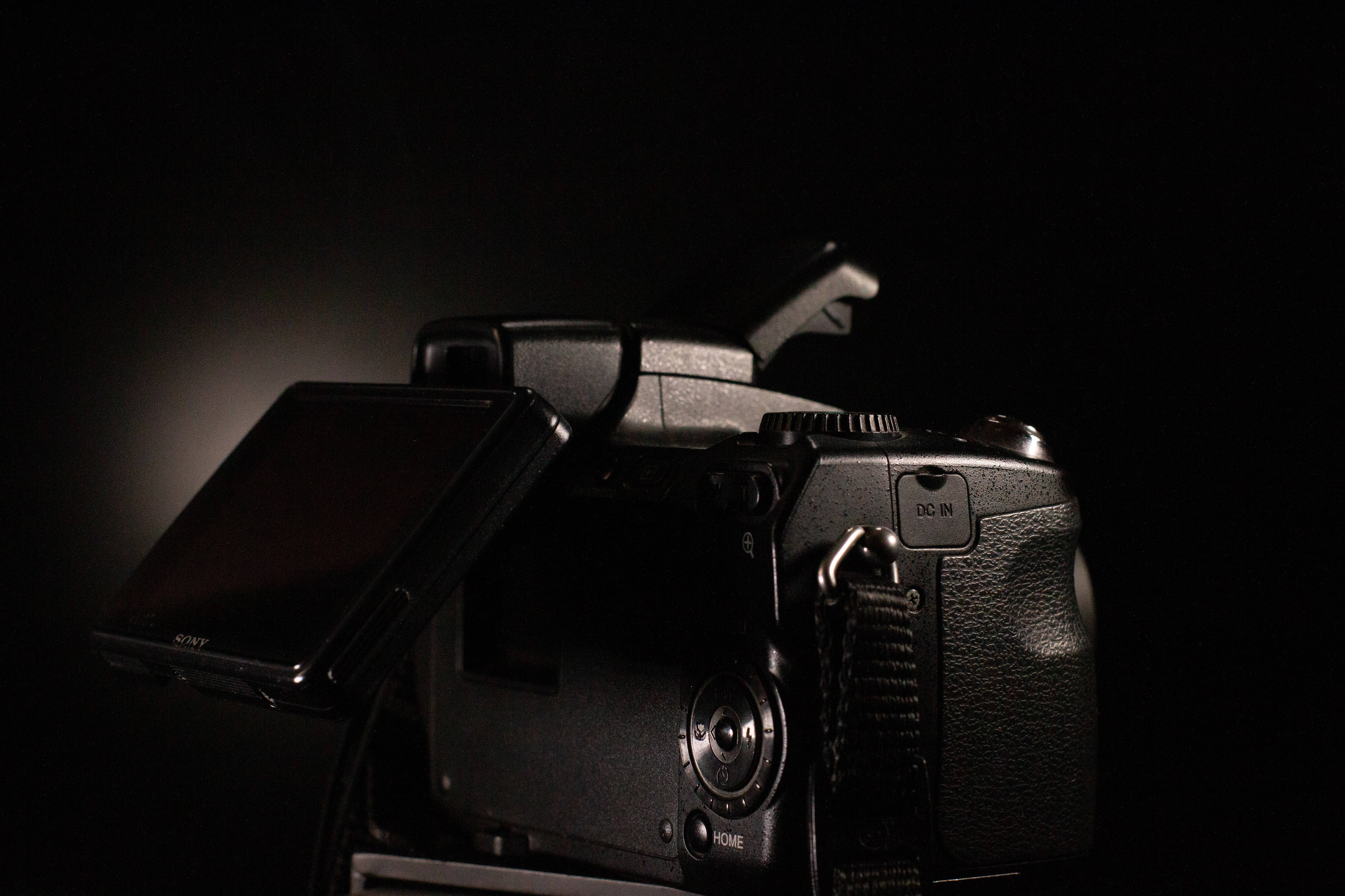 sleek black DSLR camera, glowing highlight, textured grip, 5K Desktop Wallpaper