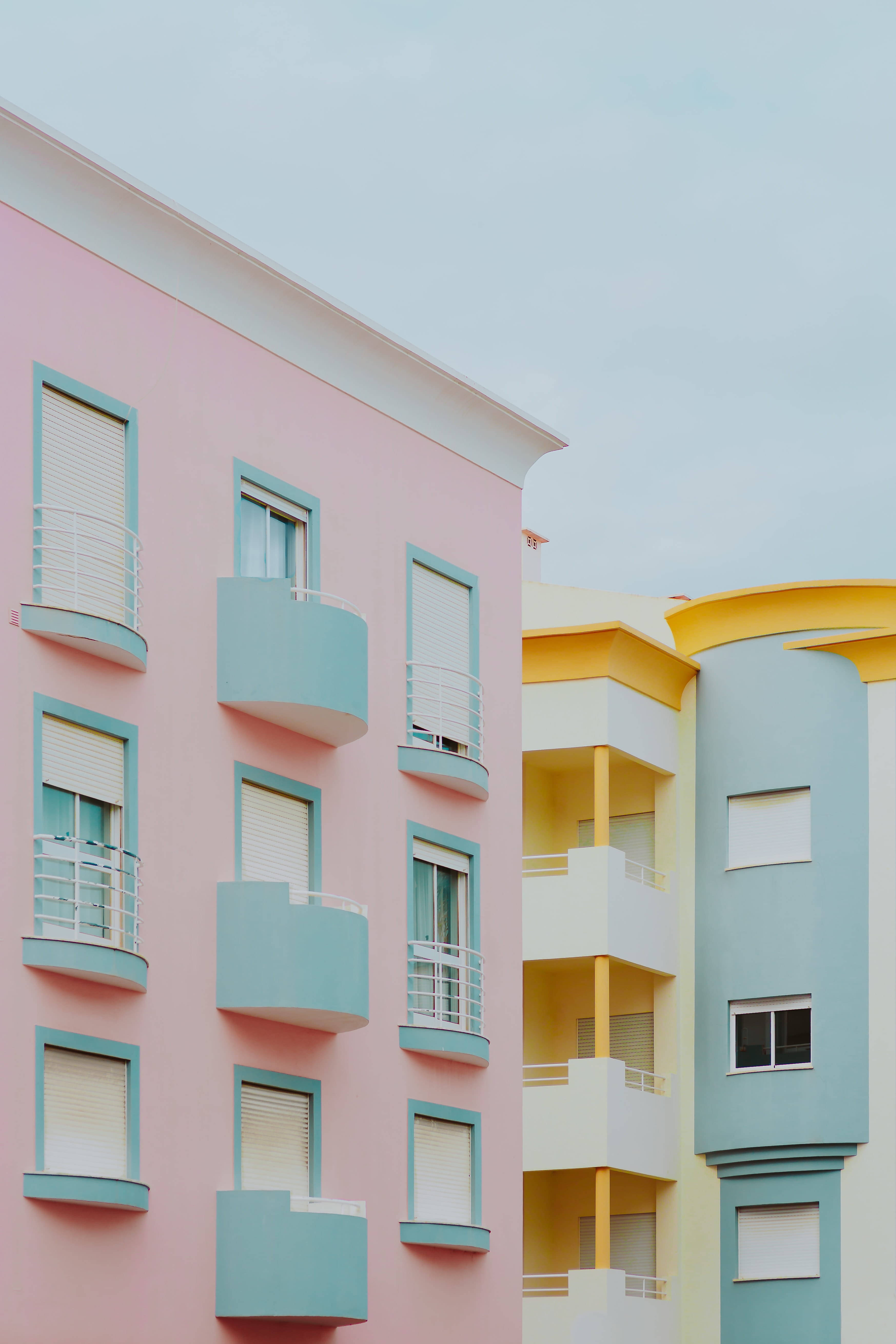 pastel-colored apartment buildings, teal balconies, yellow accents, 5K Phone Wallpaper
