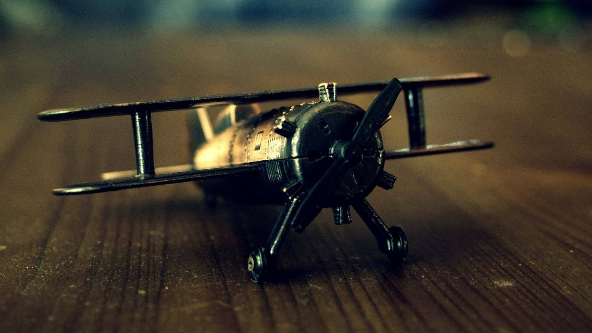 vintage biplane model, weathered wooden surface, warm cinematic lighting, Full HD Desktop Wallpaper