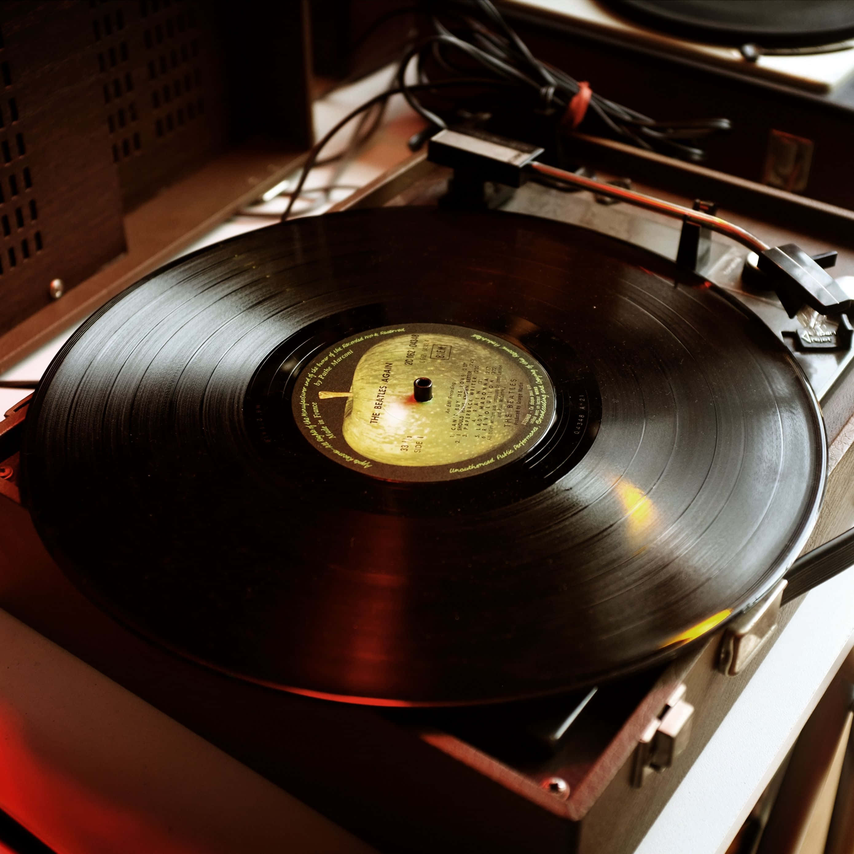 vinyl record, wooden turntable, warm ambient red light, 2K Desktop Wallpaper