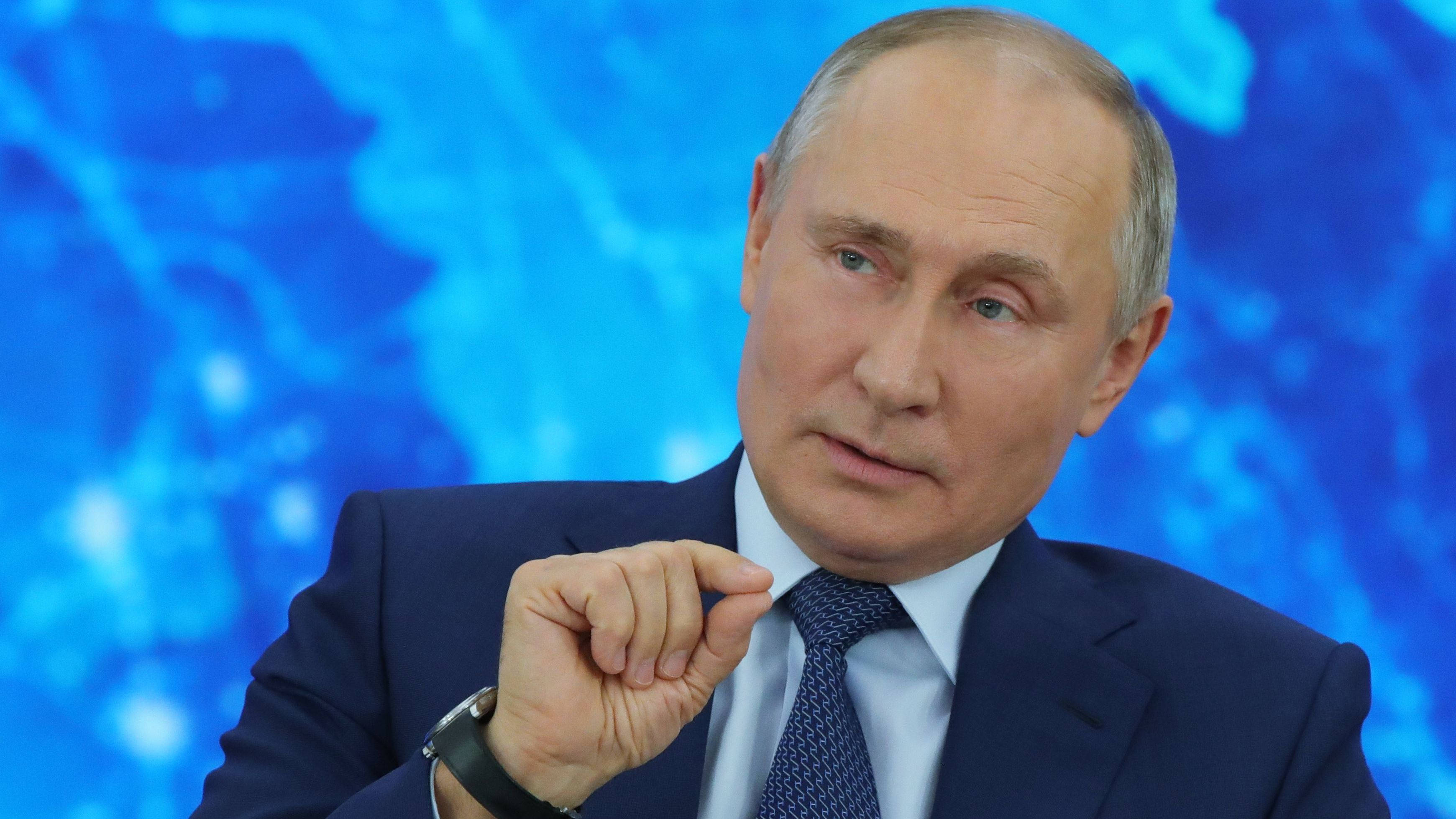 Vladimir Putin, dark suit, vibrant blue abstract background, 2K Desktop Wallpaper