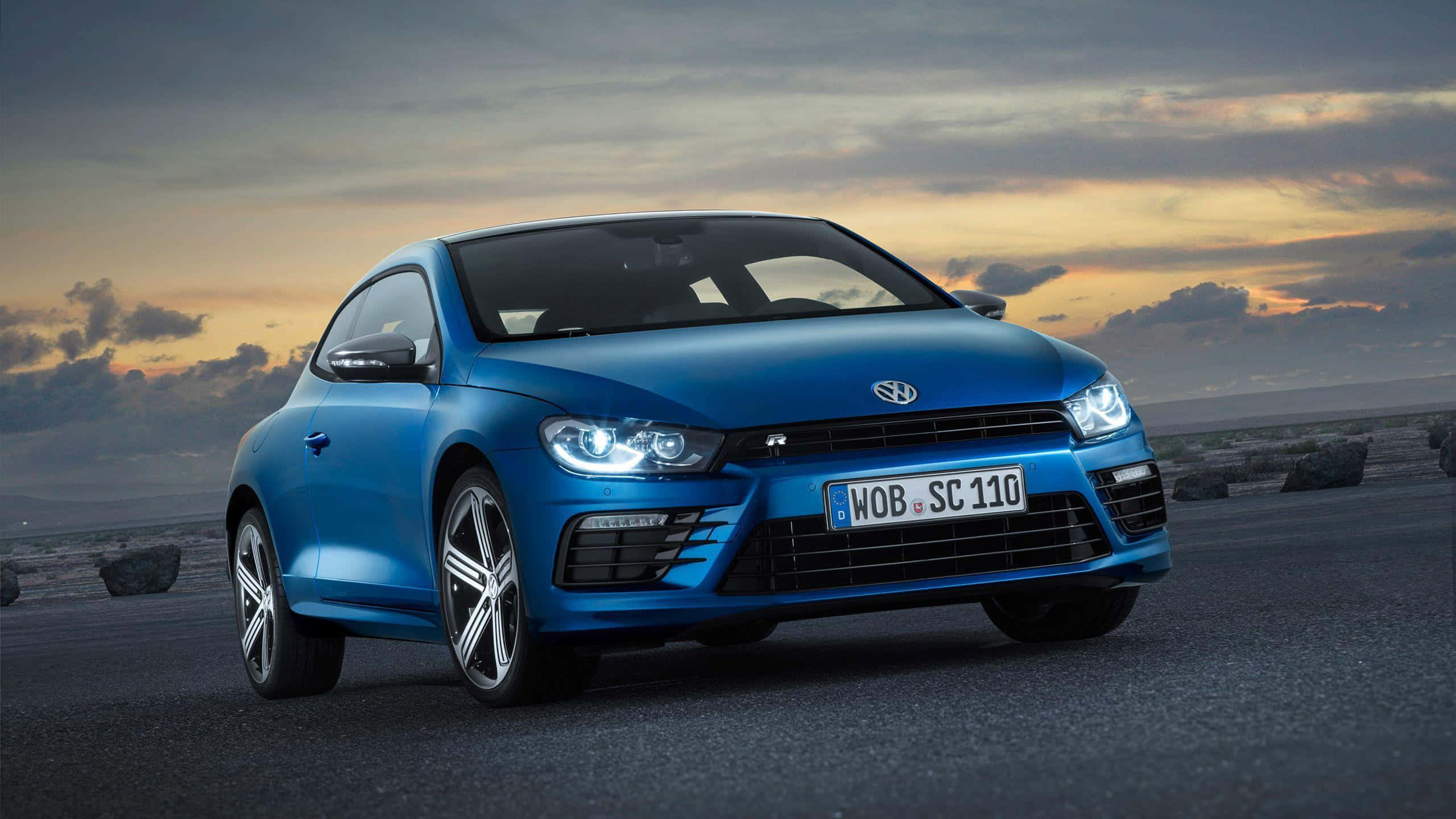 Volkswagen Scirocco, vibrant blue, dramatic sunset sky, 2K Desktop Wallpaper
