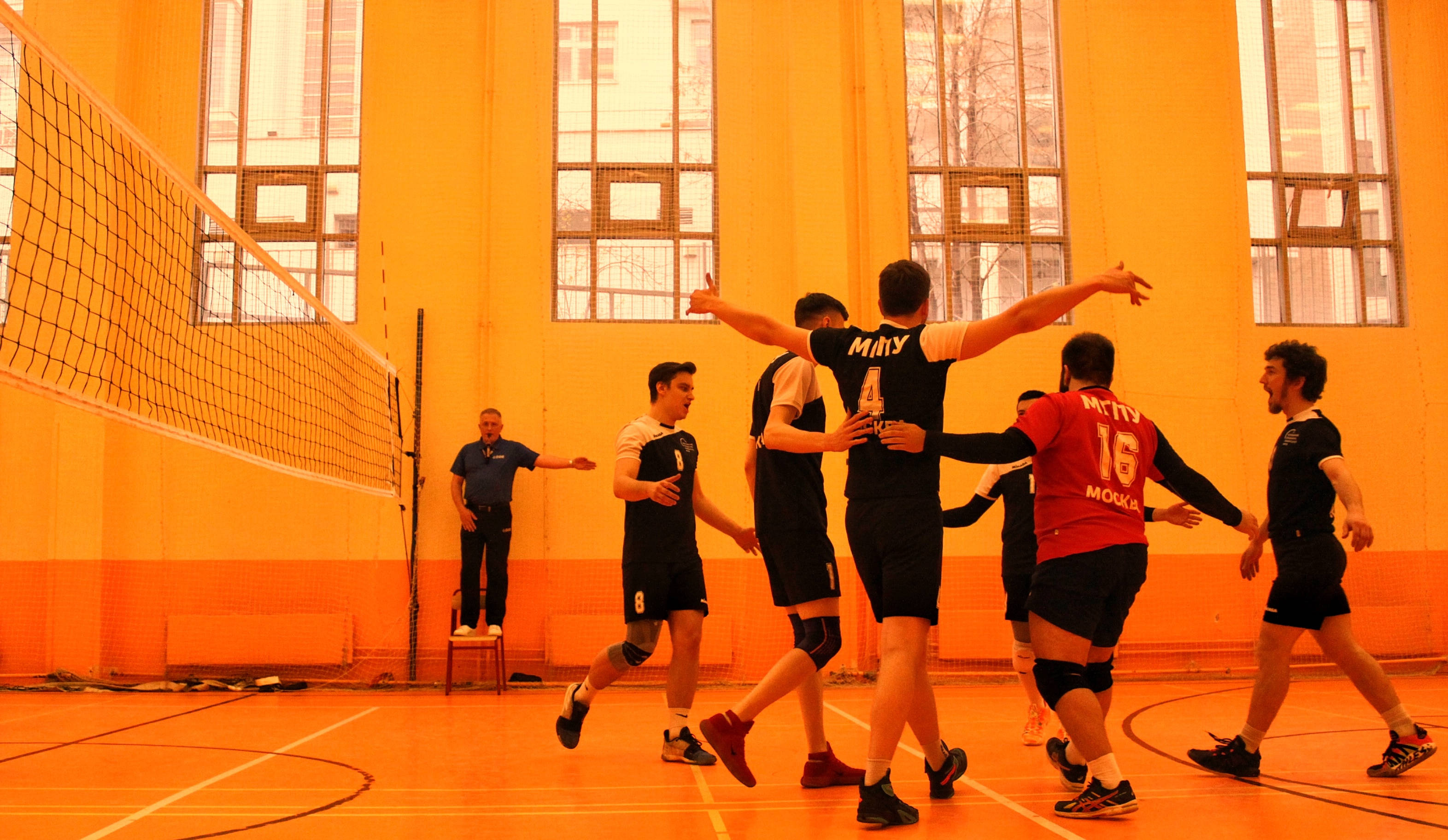 Volleyball, black and red jerseys, warm orange gym lighting, 2K Desktop Wallpaper