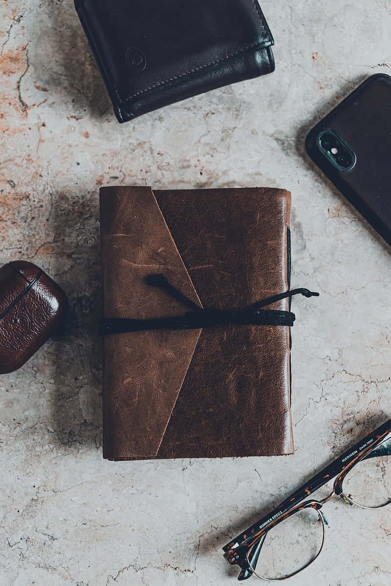 brown leather journal, black cord, marble surface, SD Phone Wallpaper