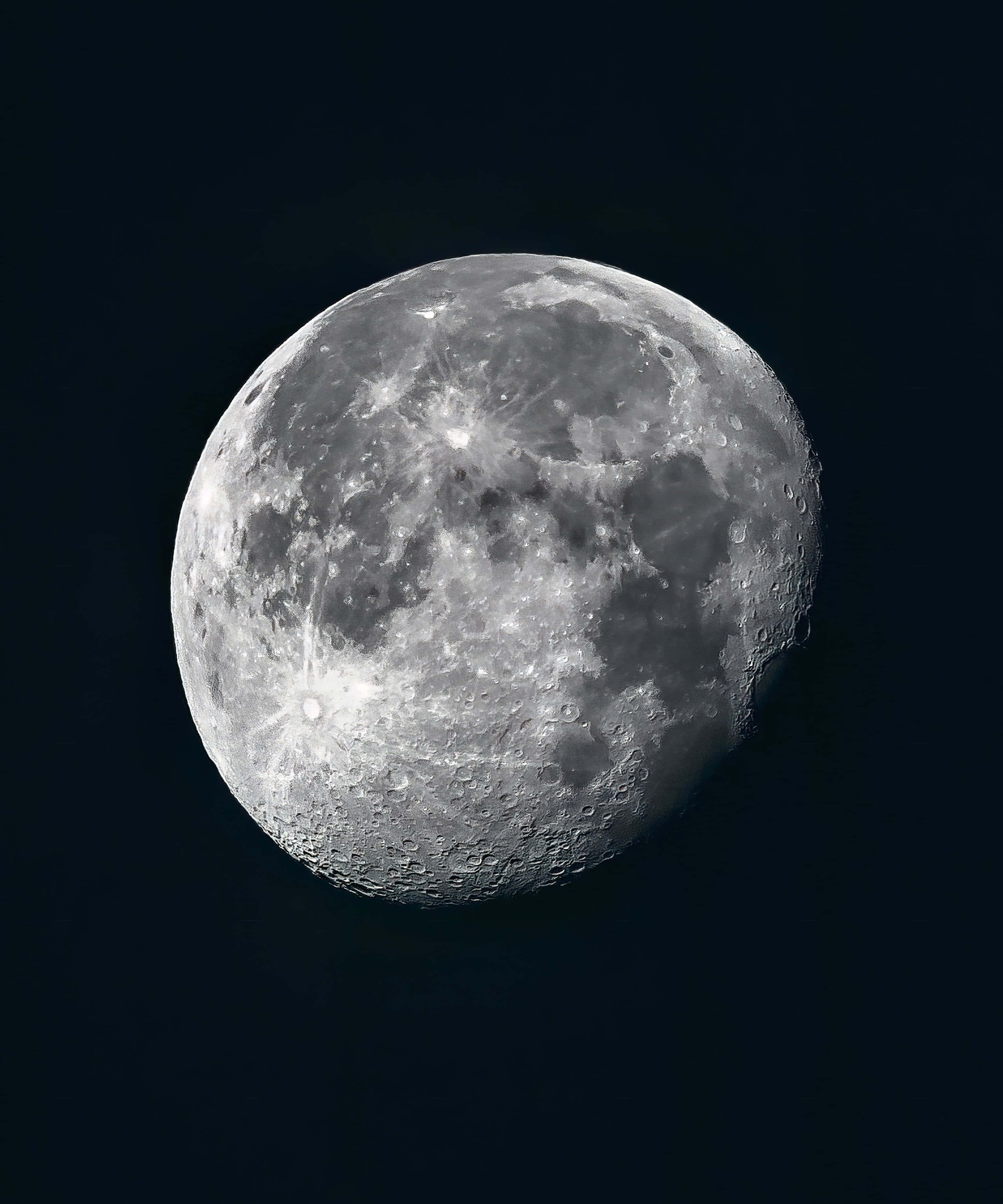 Waning Gibbous Moon, cratered surface, deep black sky, 2K Phone Wallpaper