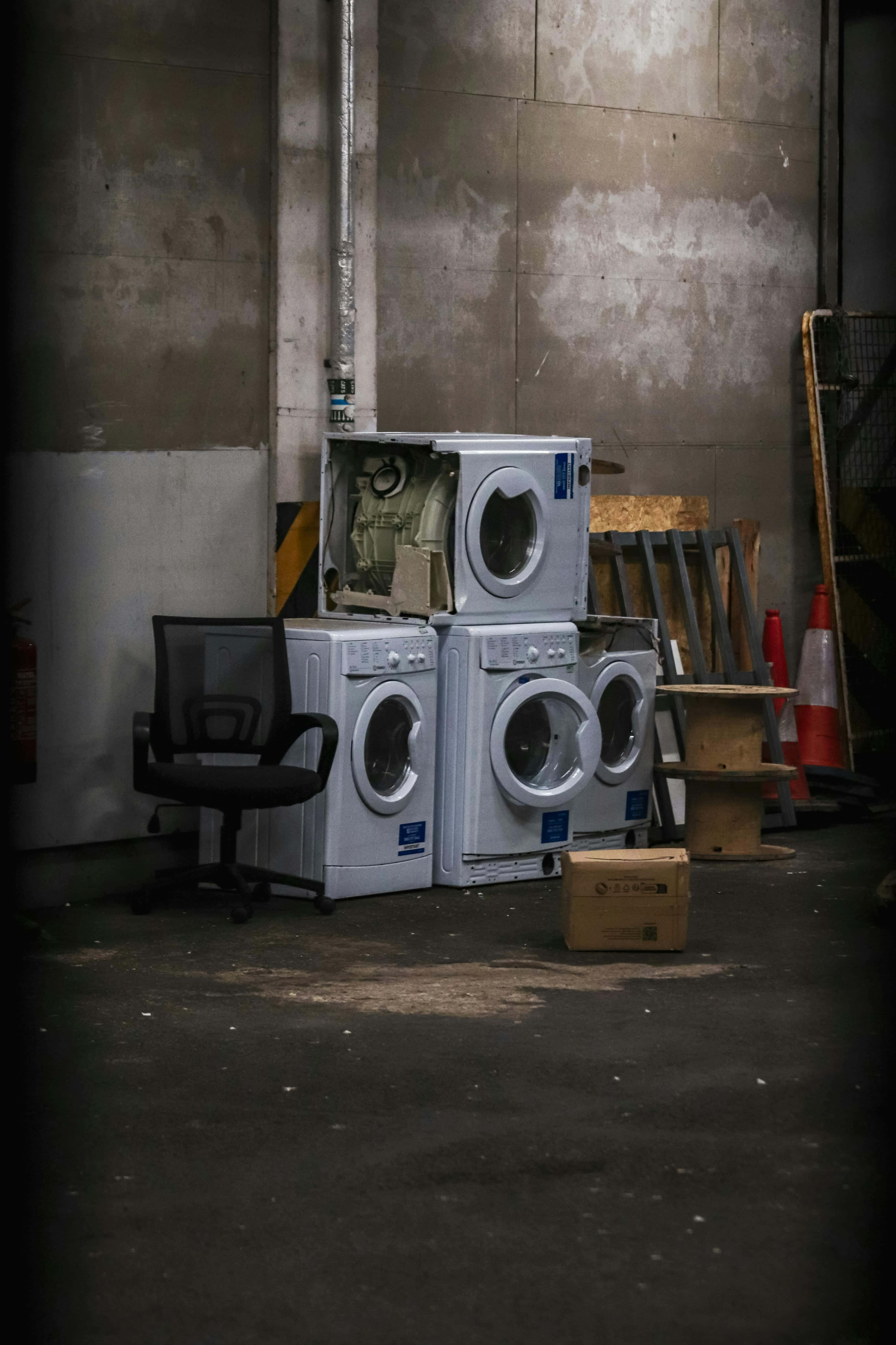 white washing machines, dim industrial warehouse, black office chair, 5K Phone Wallpaper