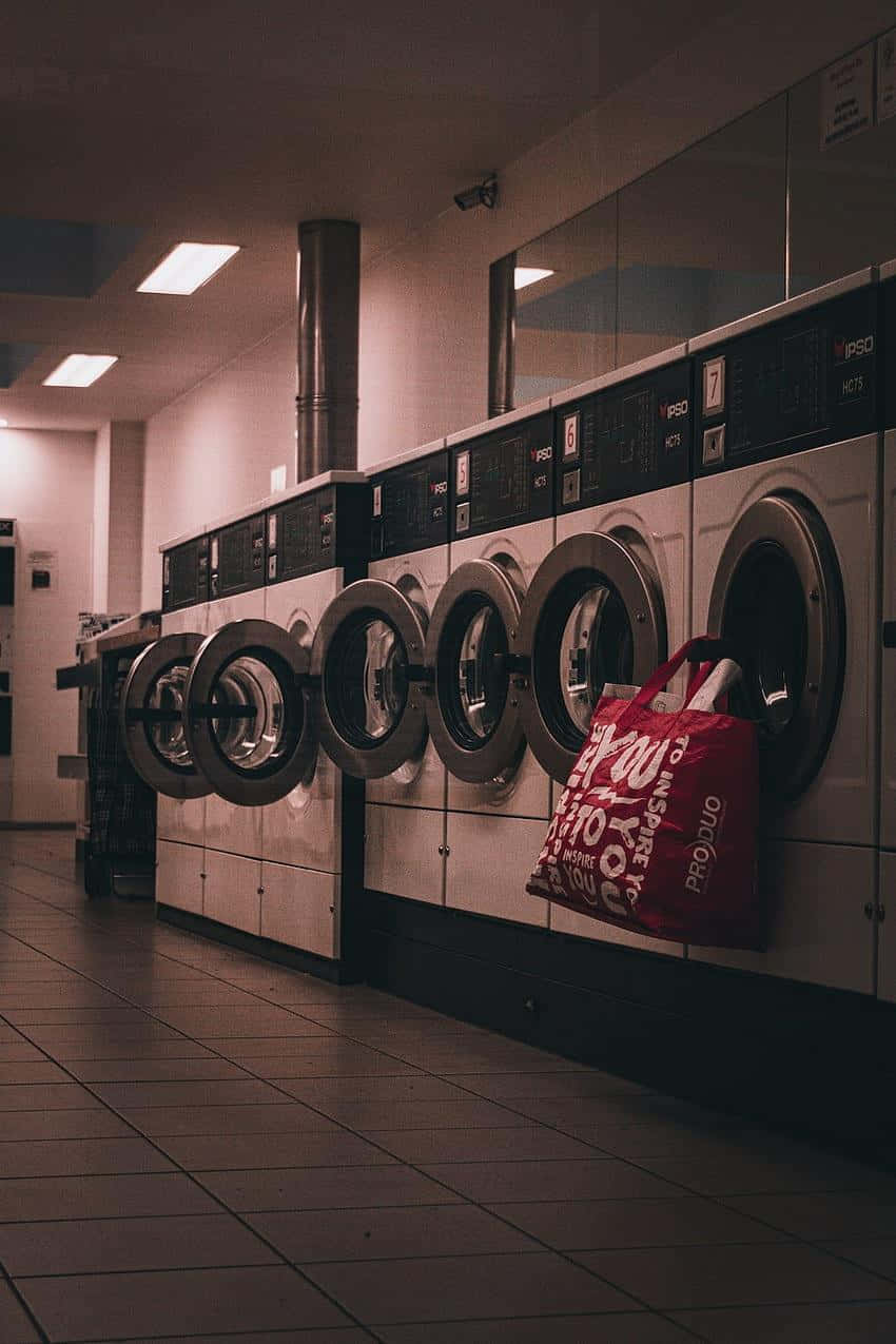 industrial washing machines, dimly lit laundromat, red bag, SD Phone Wallpaper