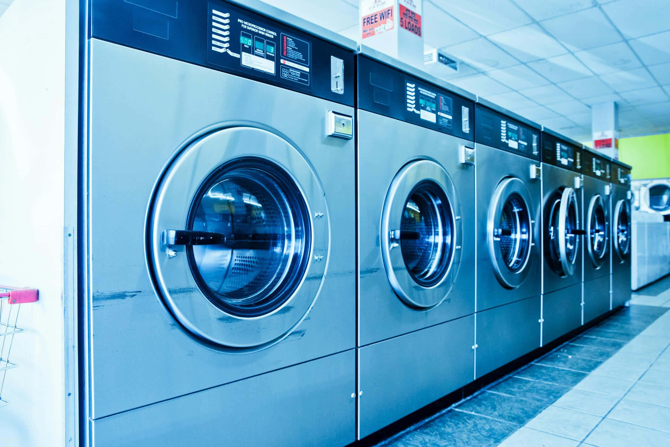 sleek stainless steel industrial washing machines, brightly lit laundromat, tiled floors, 2K Desktop Wallpaper