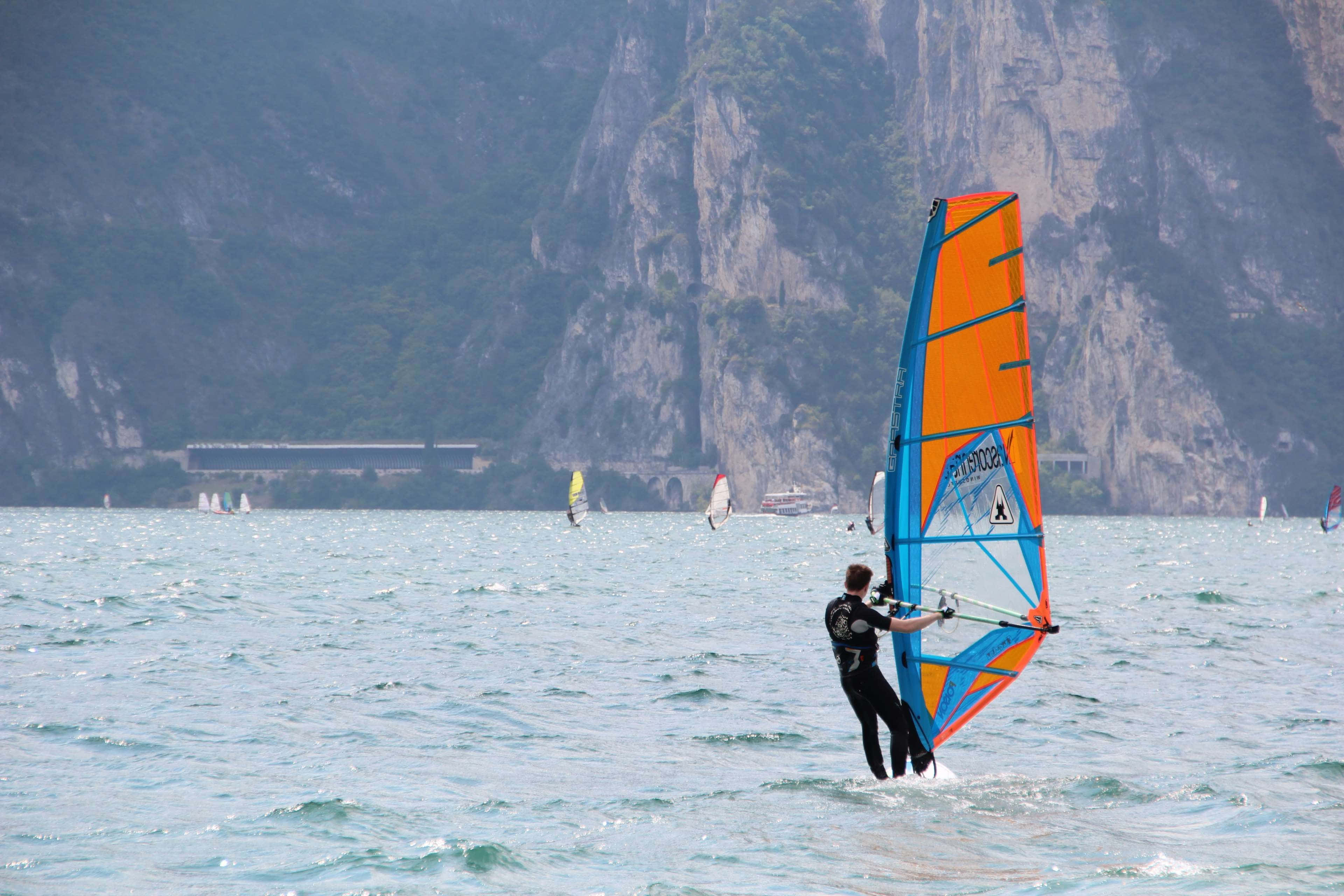 windsurfer, sunlit lake, vibrant orange and blue sail, 4K Desktop Wallpaper