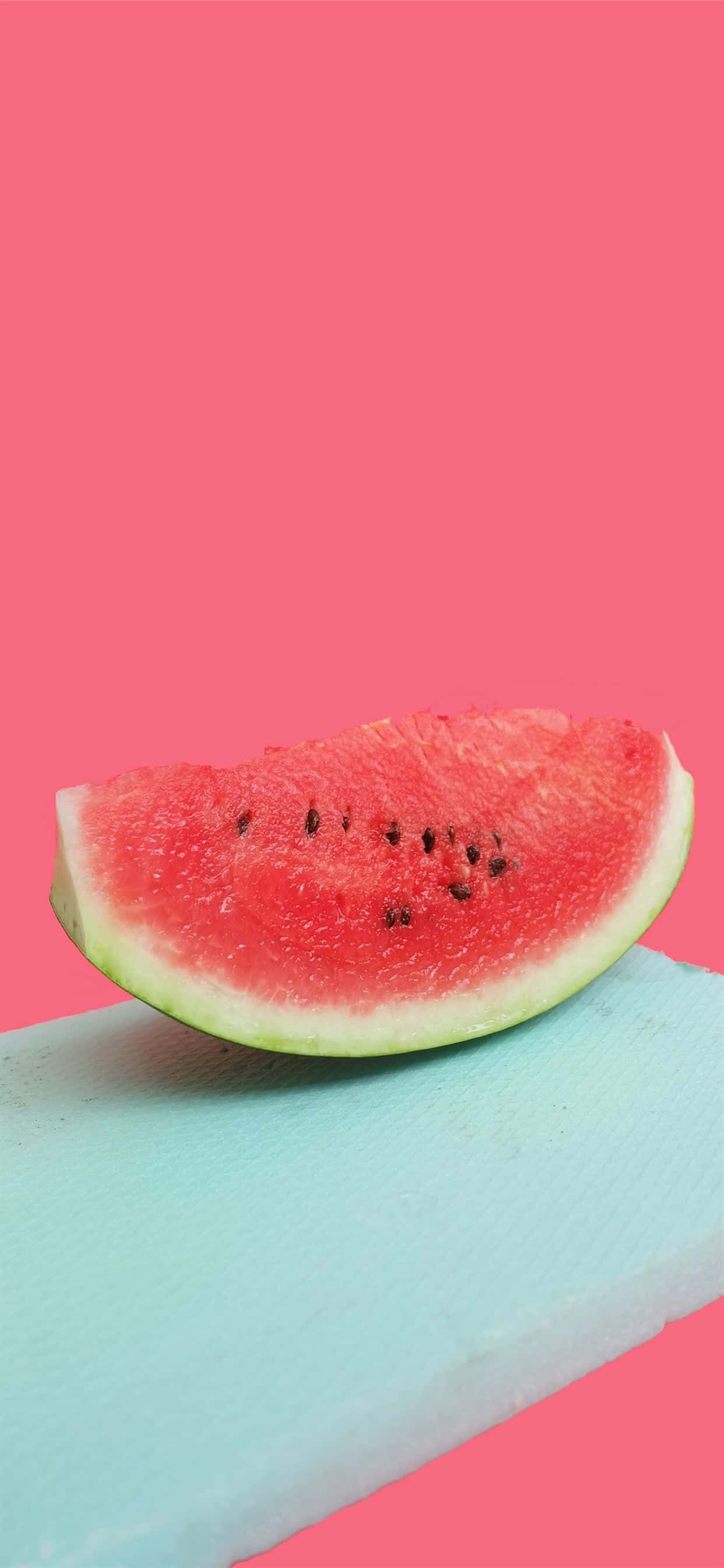 Watermelon iPhone, black seeds, light blue cutting board, 2K Phone Wallpaper