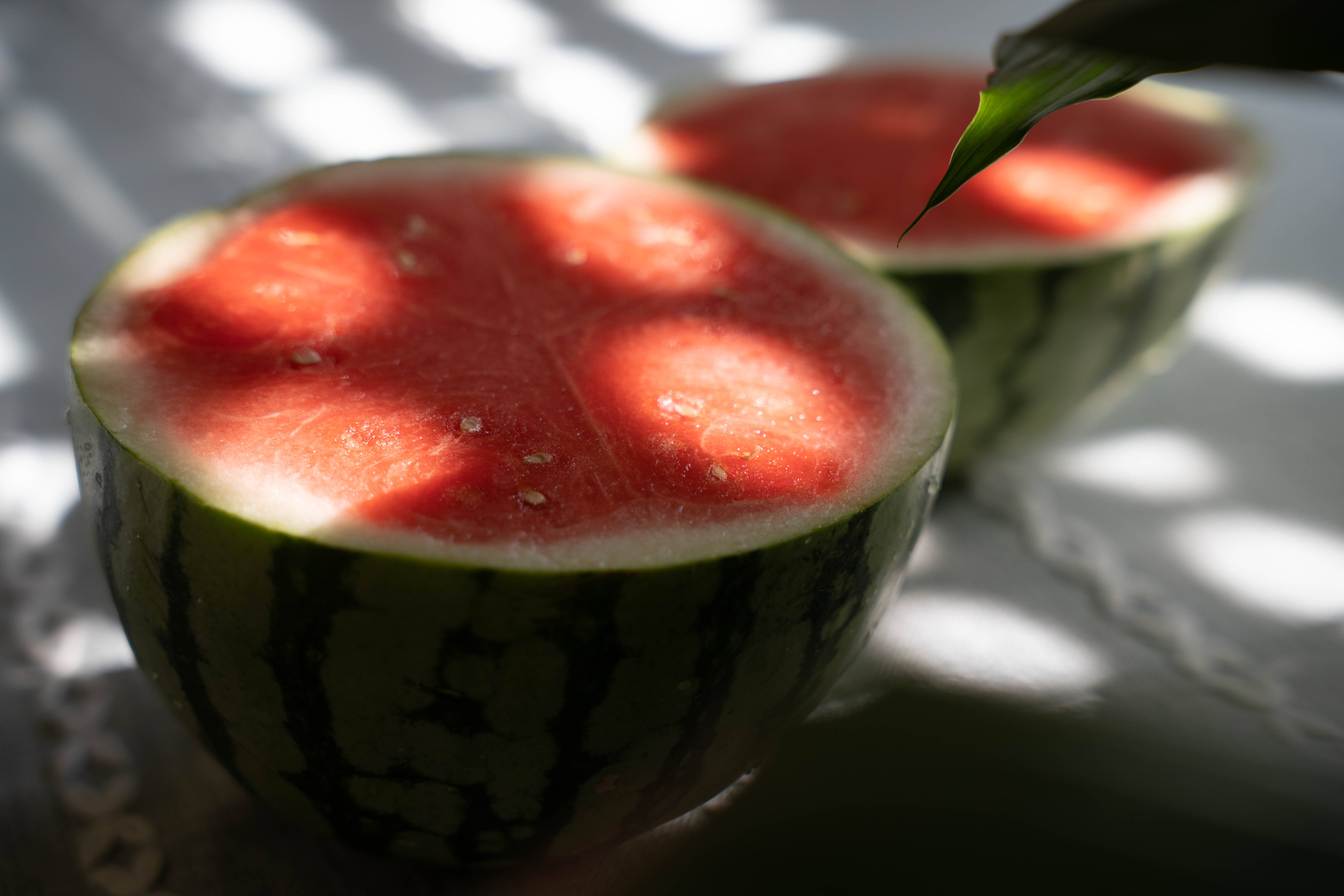 halved watermelon, dappled sunlight, leafy shadows, 5K Desktop Wallpaper