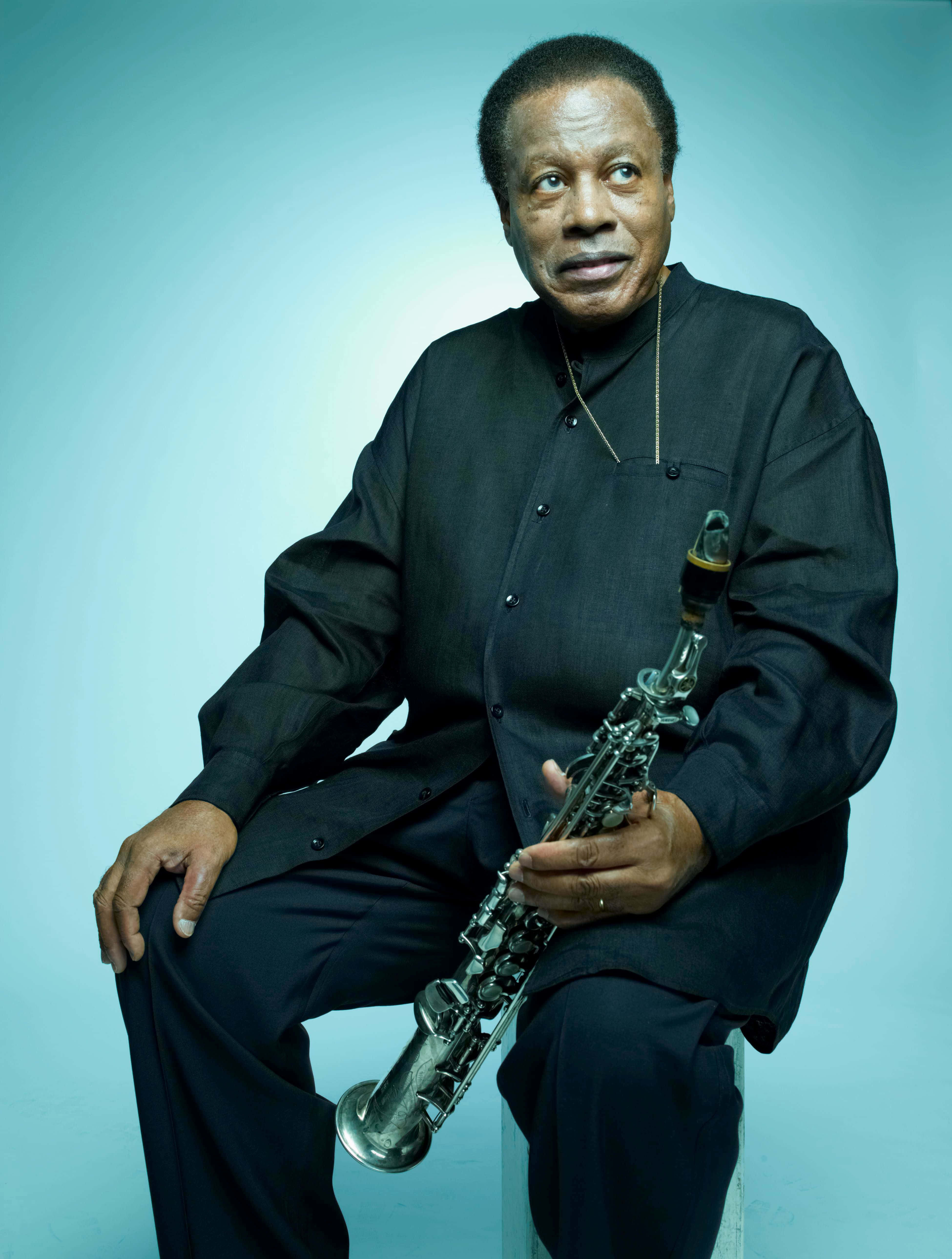 Wayne Shorter, black outfit, blue studio backdrop, 5K Phone Wallpaper