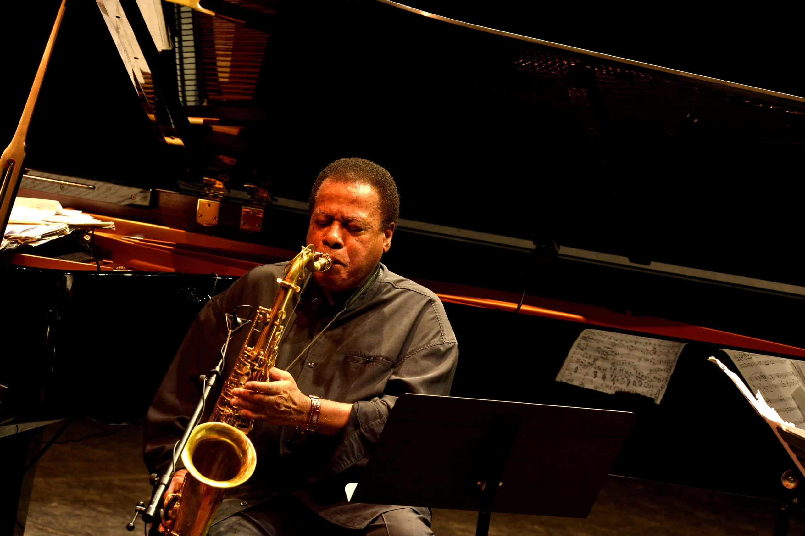 Wayne Shorter, golden saxophone, warm stage lights, 2K Desktop Wallpaper