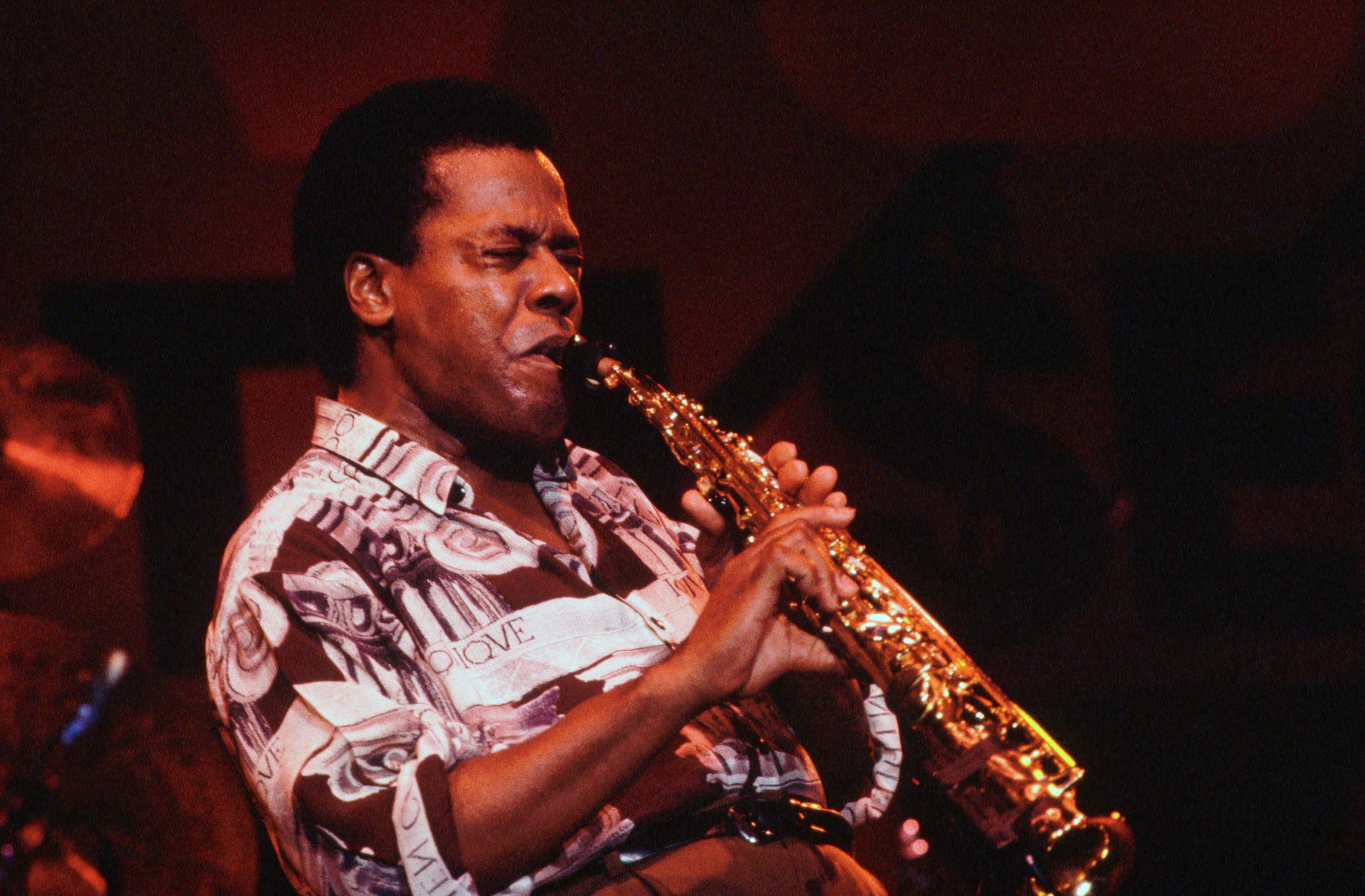 Wayne Shorter, golden saxophone, warm stage lights, 2K Desktop Wallpaper