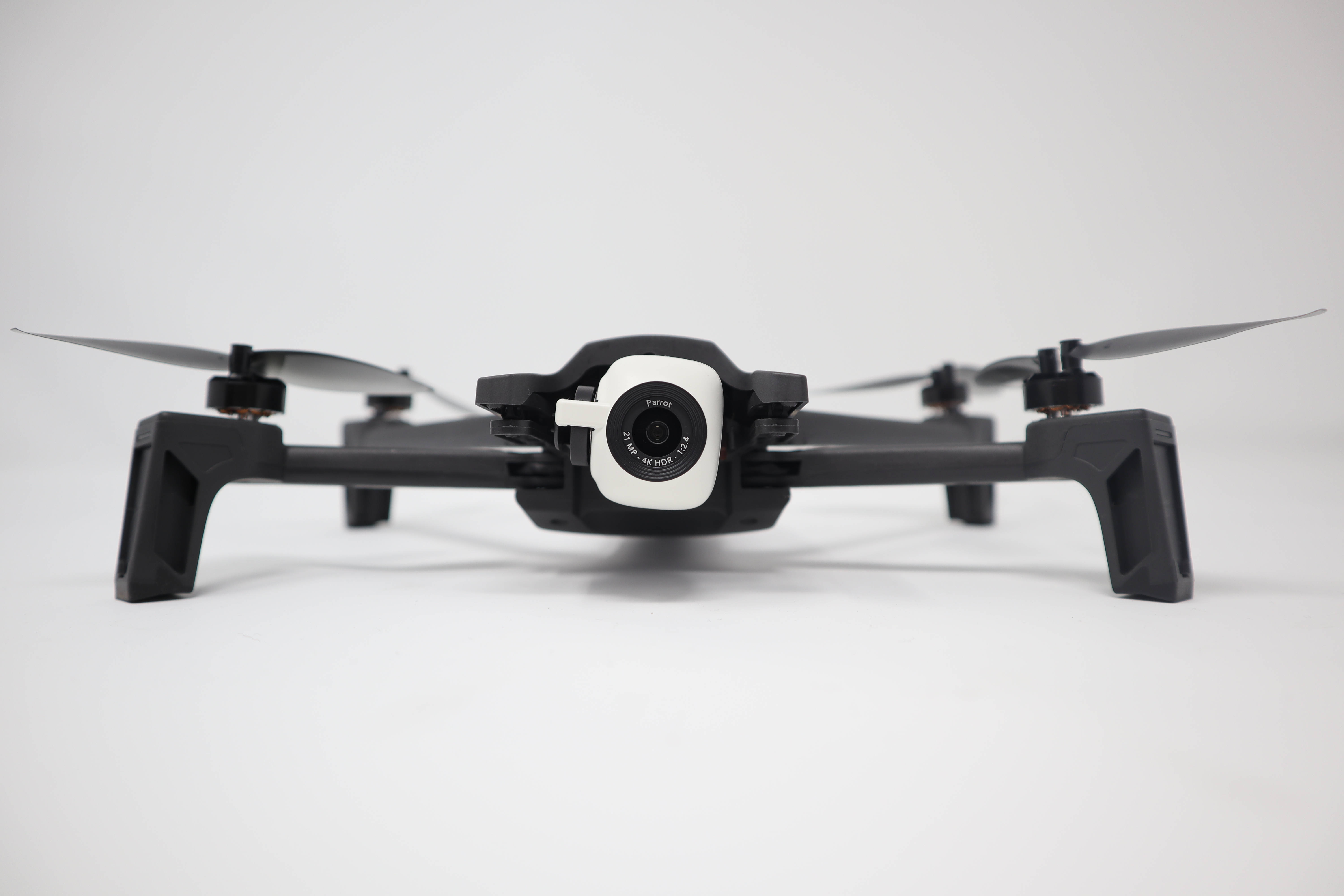 black drone, white camera lens, minimalist white surface, 5K Desktop Wallpaper