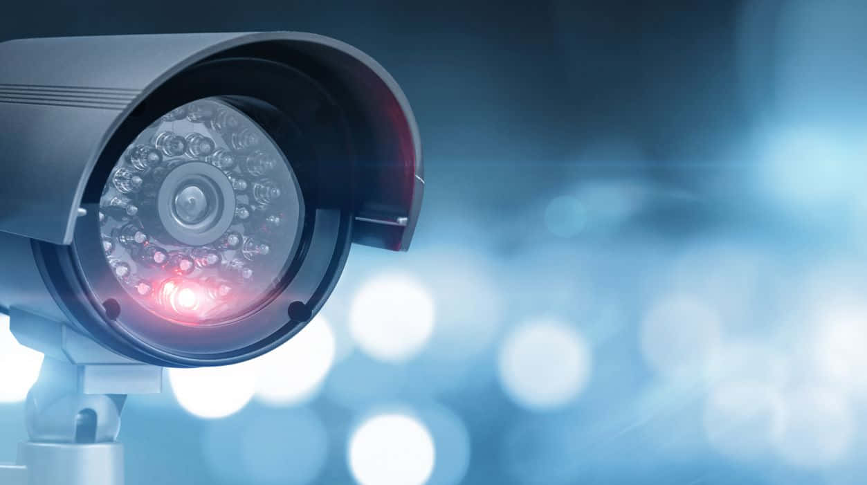 CCTV security camera, glowing red LED, blurred blue bokeh background, SD Desktop Wallpaper