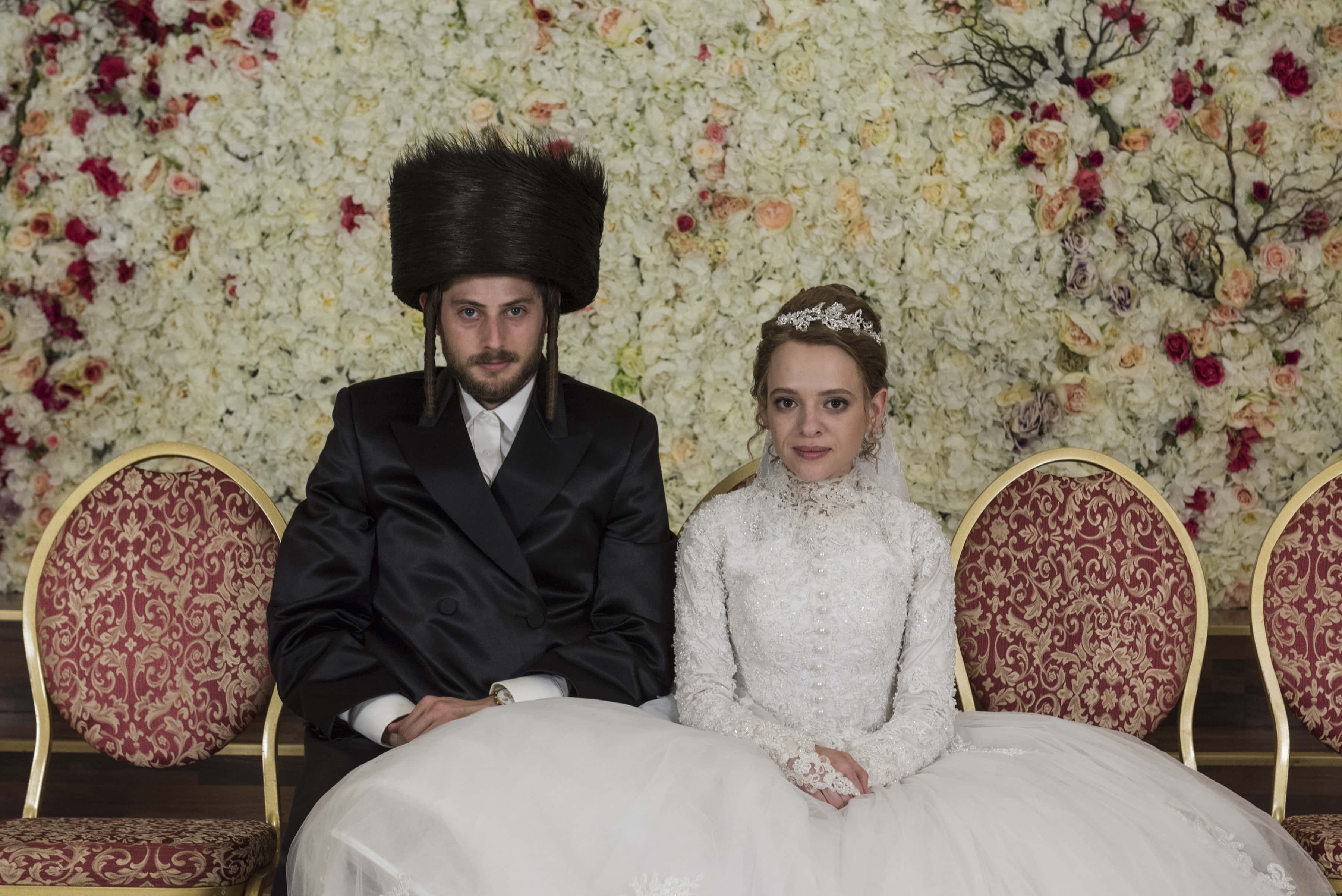 Jewish couple, traditional wedding attire, lavish floral wall, 2K Desktop Wallpaper