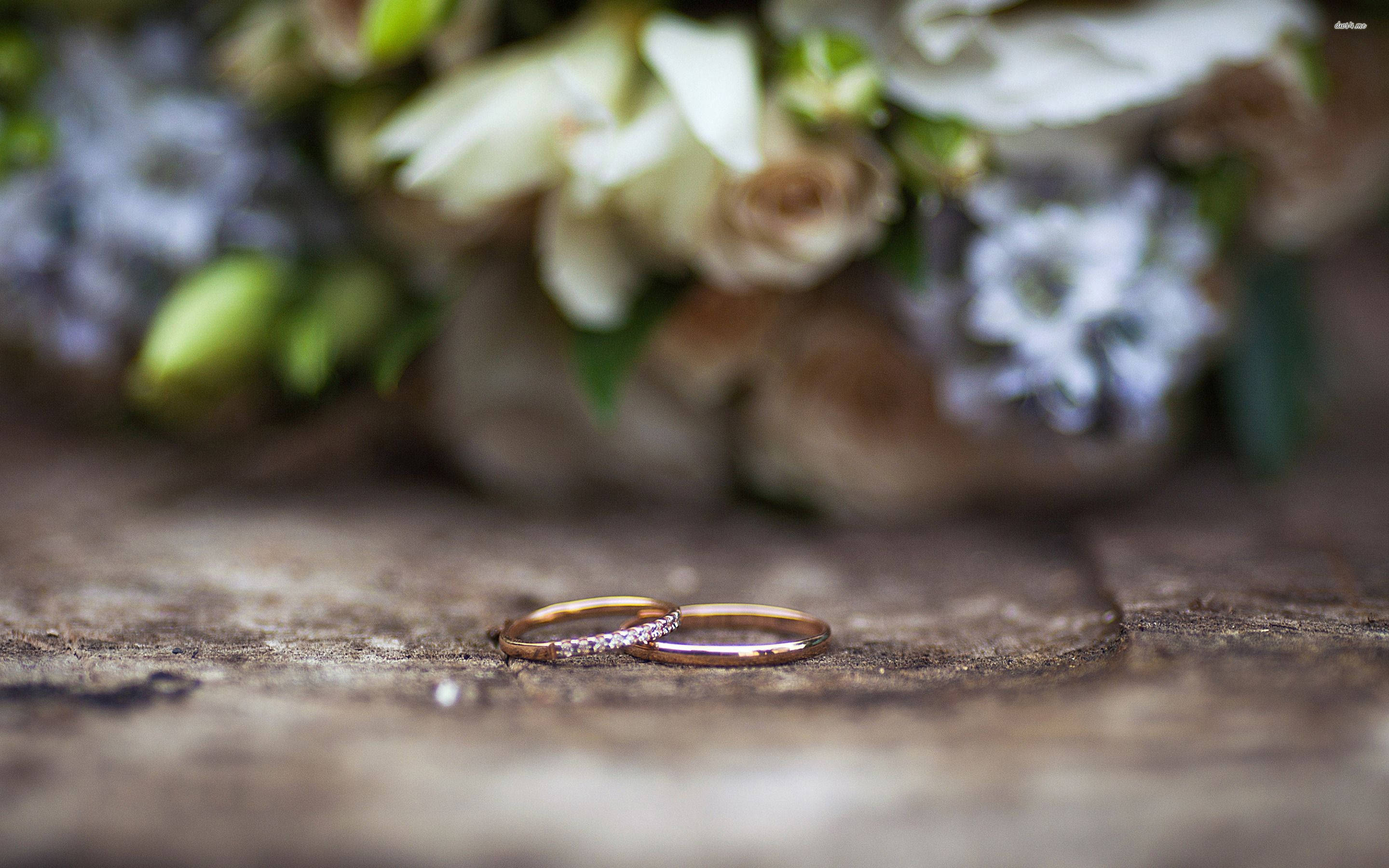 rose gold wedding bands, weathered wood, soft-focus floral bouquet, 2K Desktop Wallpaper