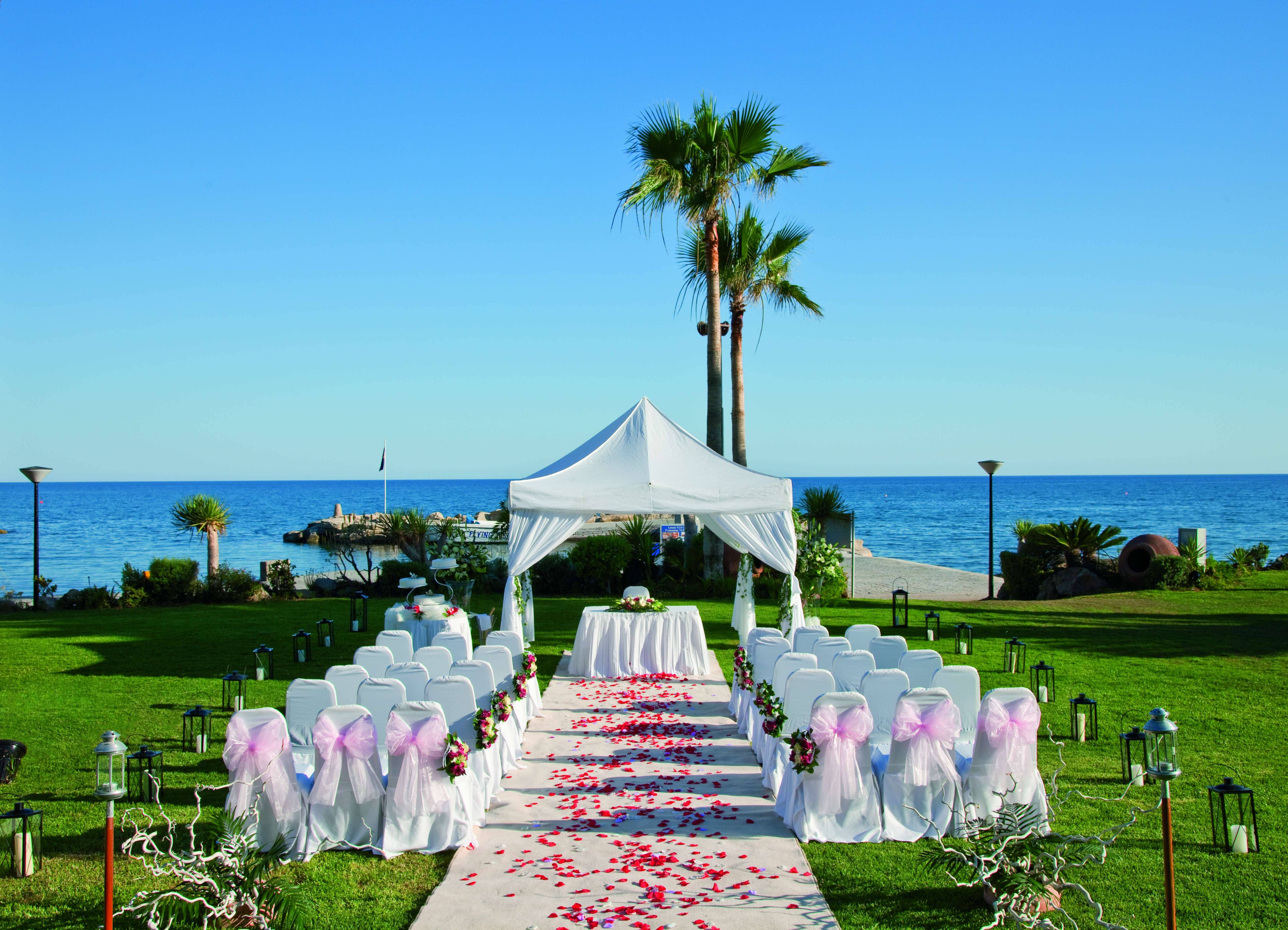 beach wedding setup, white chairs, pink bows, 4K Desktop Wallpaper