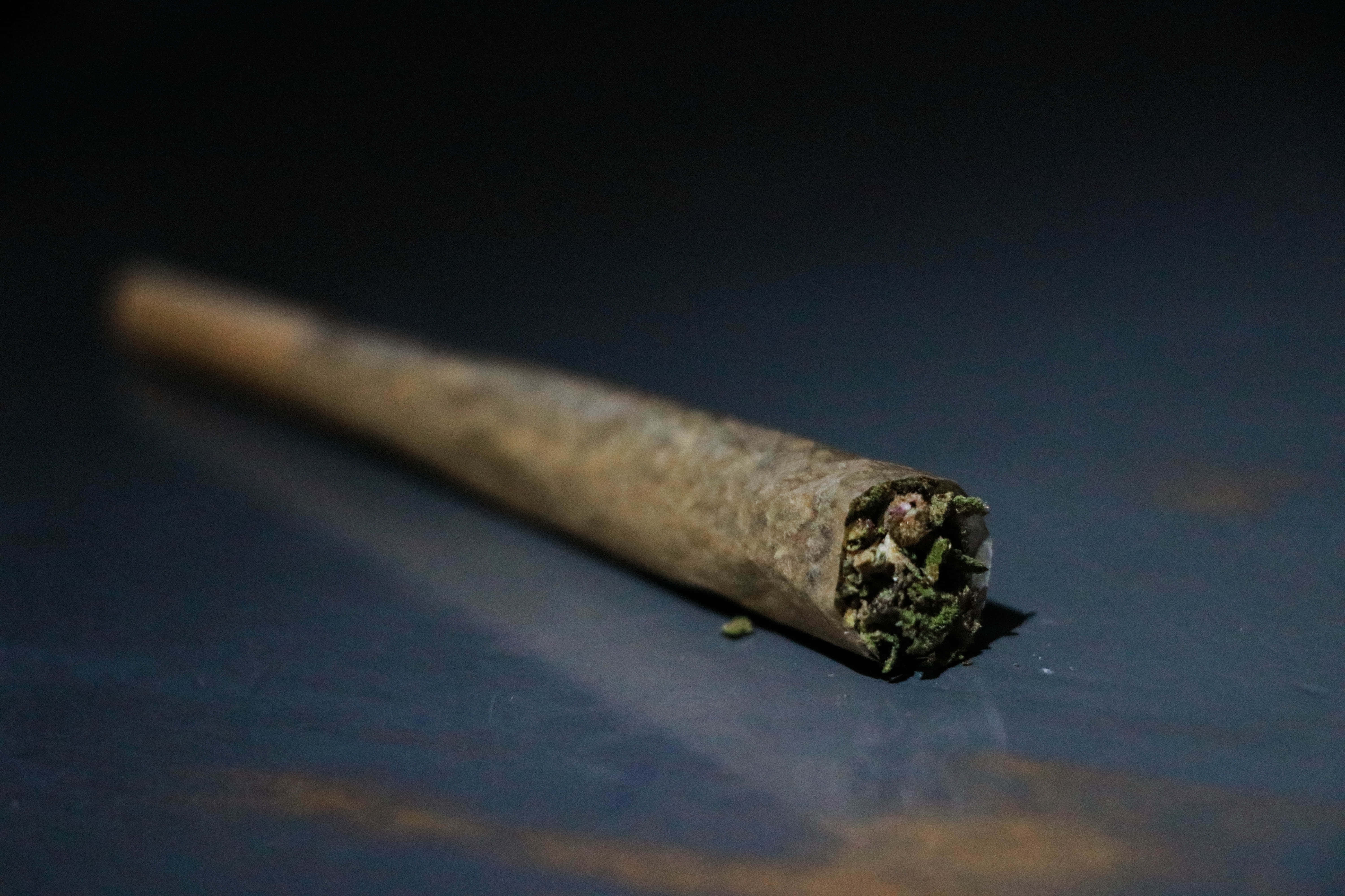 Weed Blunt, lit cannabis joint, dark reflective surface, 5K Desktop Wallpaper