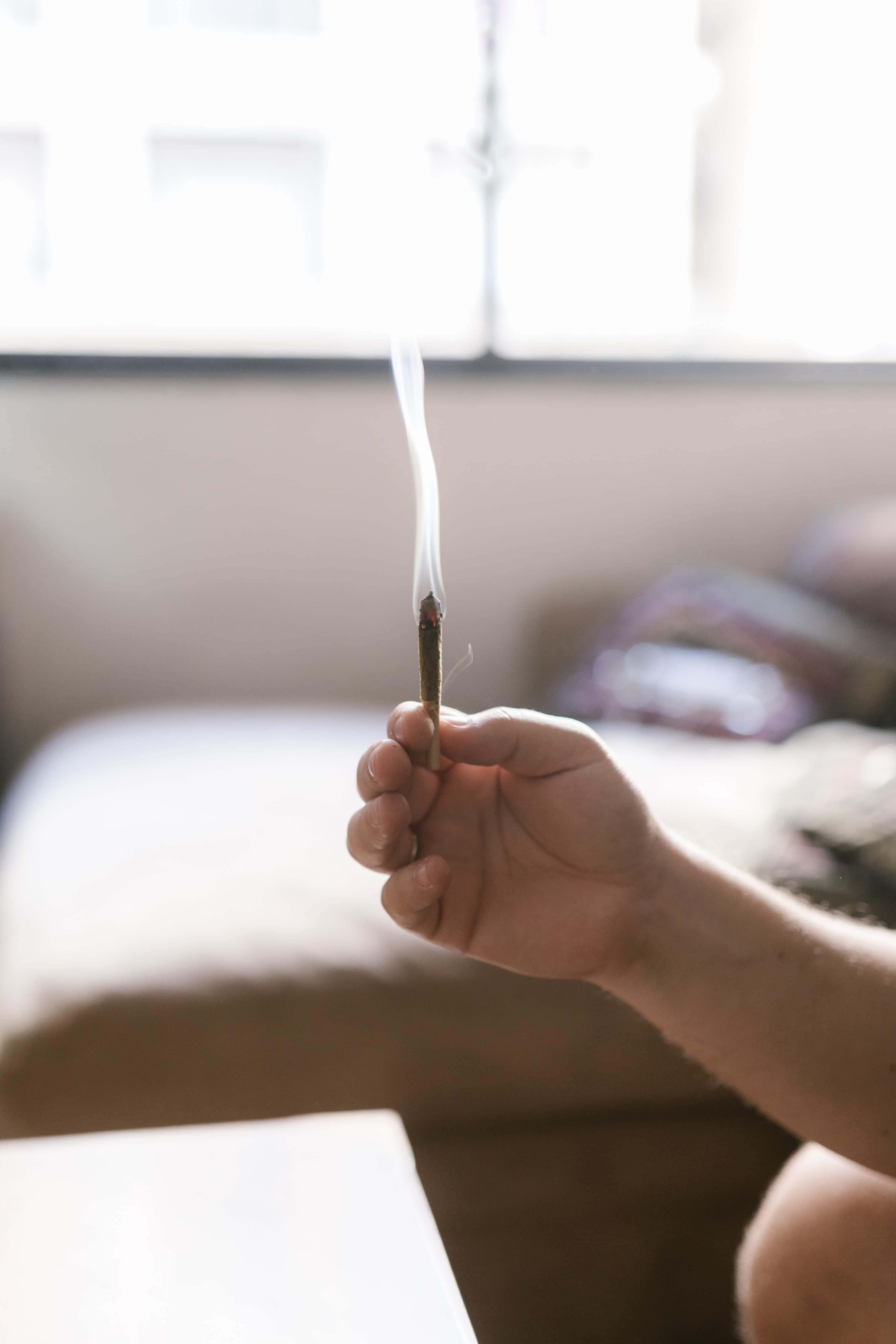 weed blunt, lit incense stick, thin wisp of smoke, 5K Phone Wallpaper