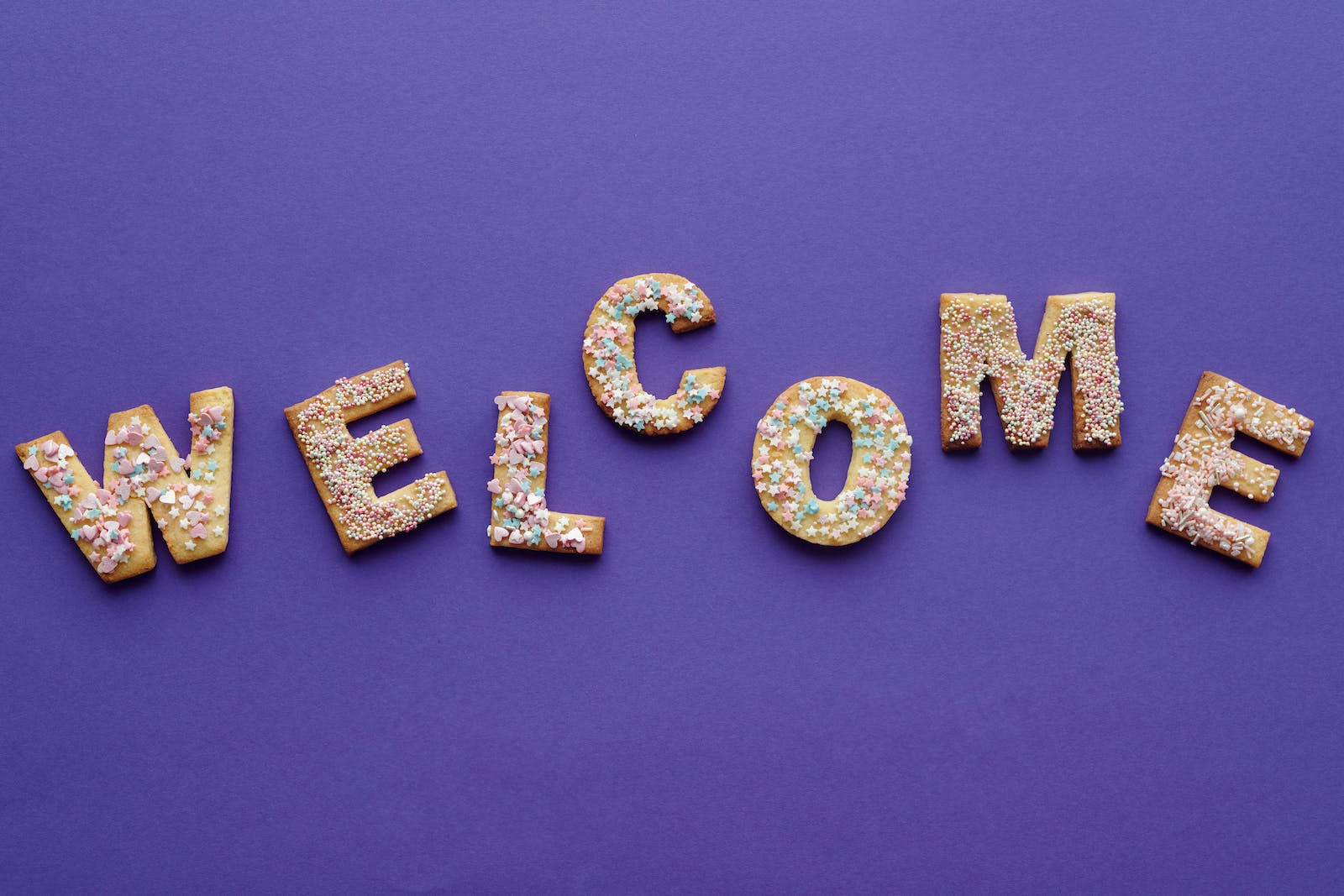 WELCOME, colorful sprinkle-covered cookies, solid purple background, HD Desktop Wallpaper
