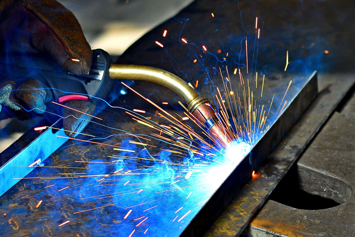 welder's gloved hand, torch emitting bright blue light, flying orange sparks, HD Desktop Wallpaper