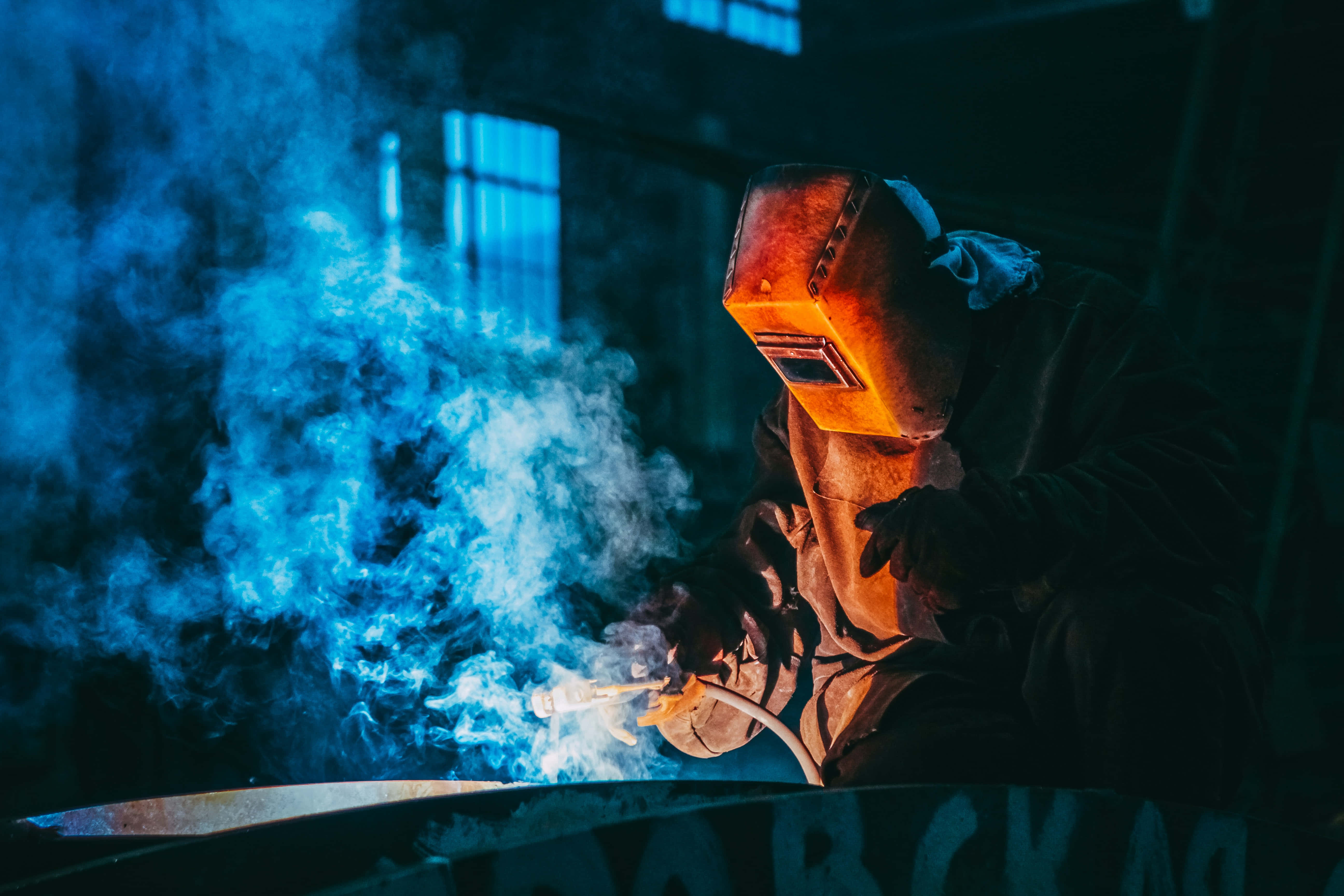 welding, glowing orange helmet, dim workshop, 5K Desktop Wallpaper