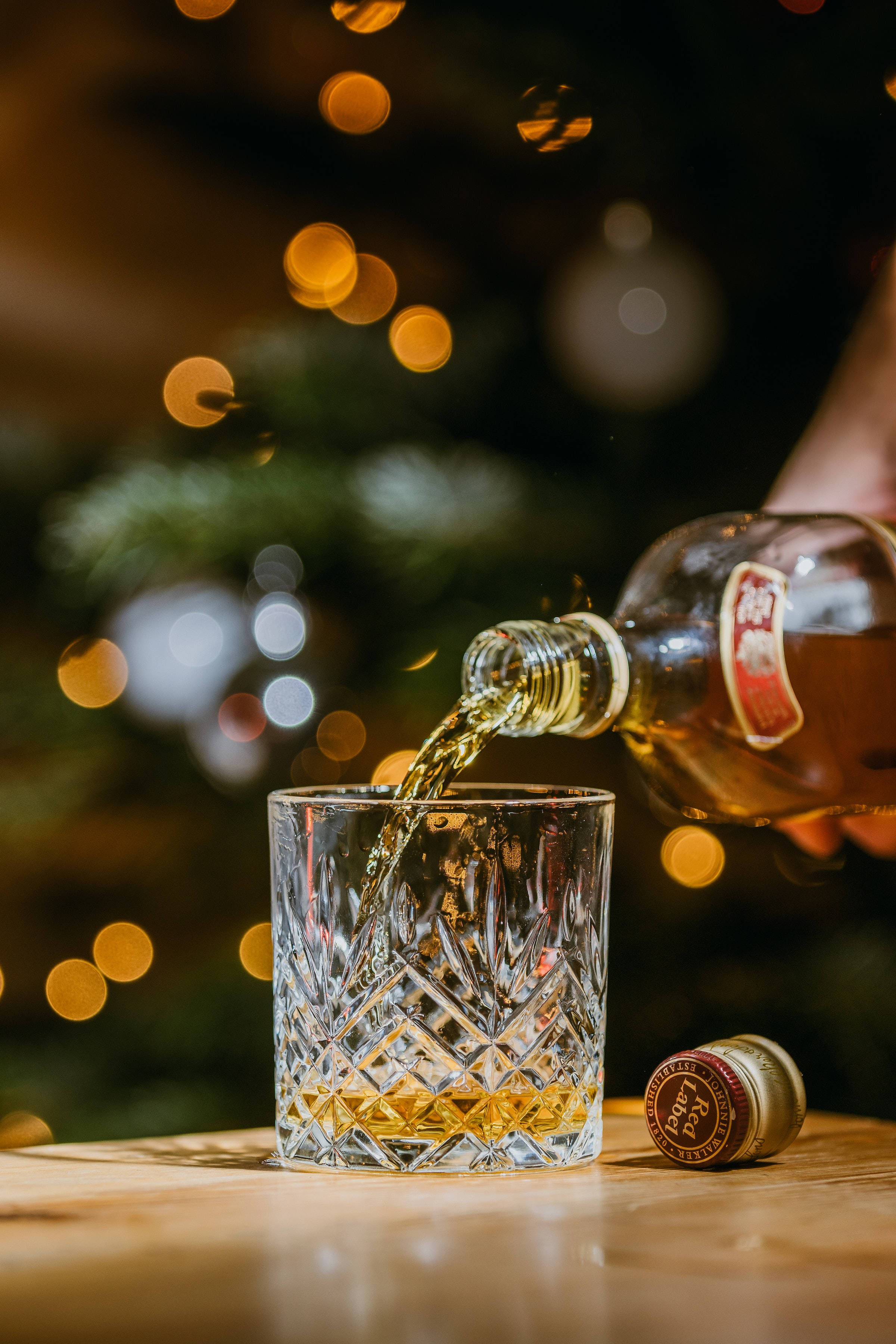 Christmas whiskey, crystal glass, bokeh-lit Christmas tree, 2K Phone Wallpaper