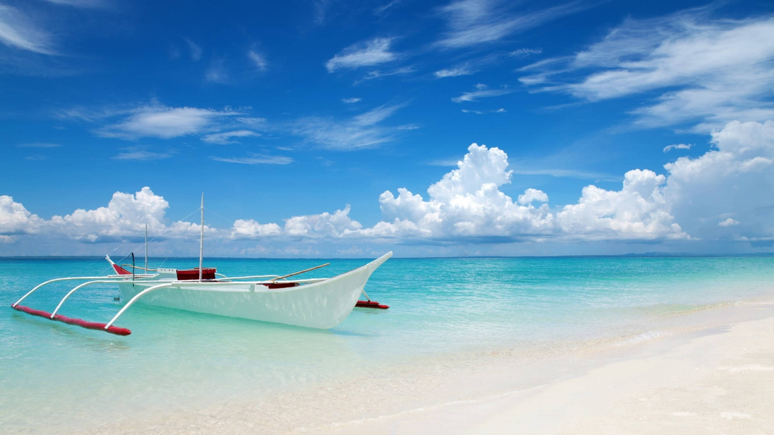 white outrigger boat, pristine white sand beach, vibrant blue sky, 2K Desktop Wallpaper