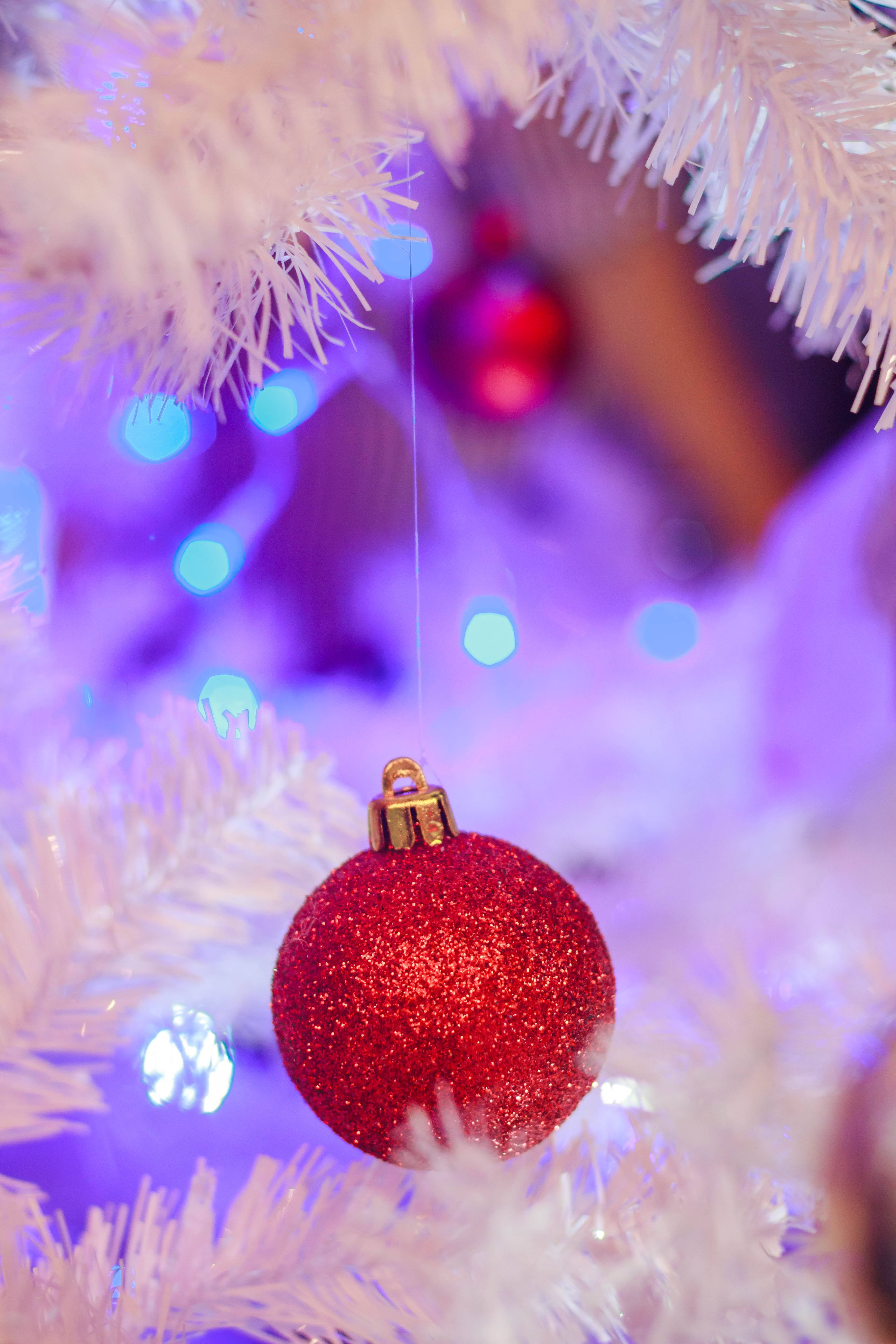 white flocked tree, sparkling red Christmas ornament, dreamy purple bokeh background, 5K Phone Wallpaper