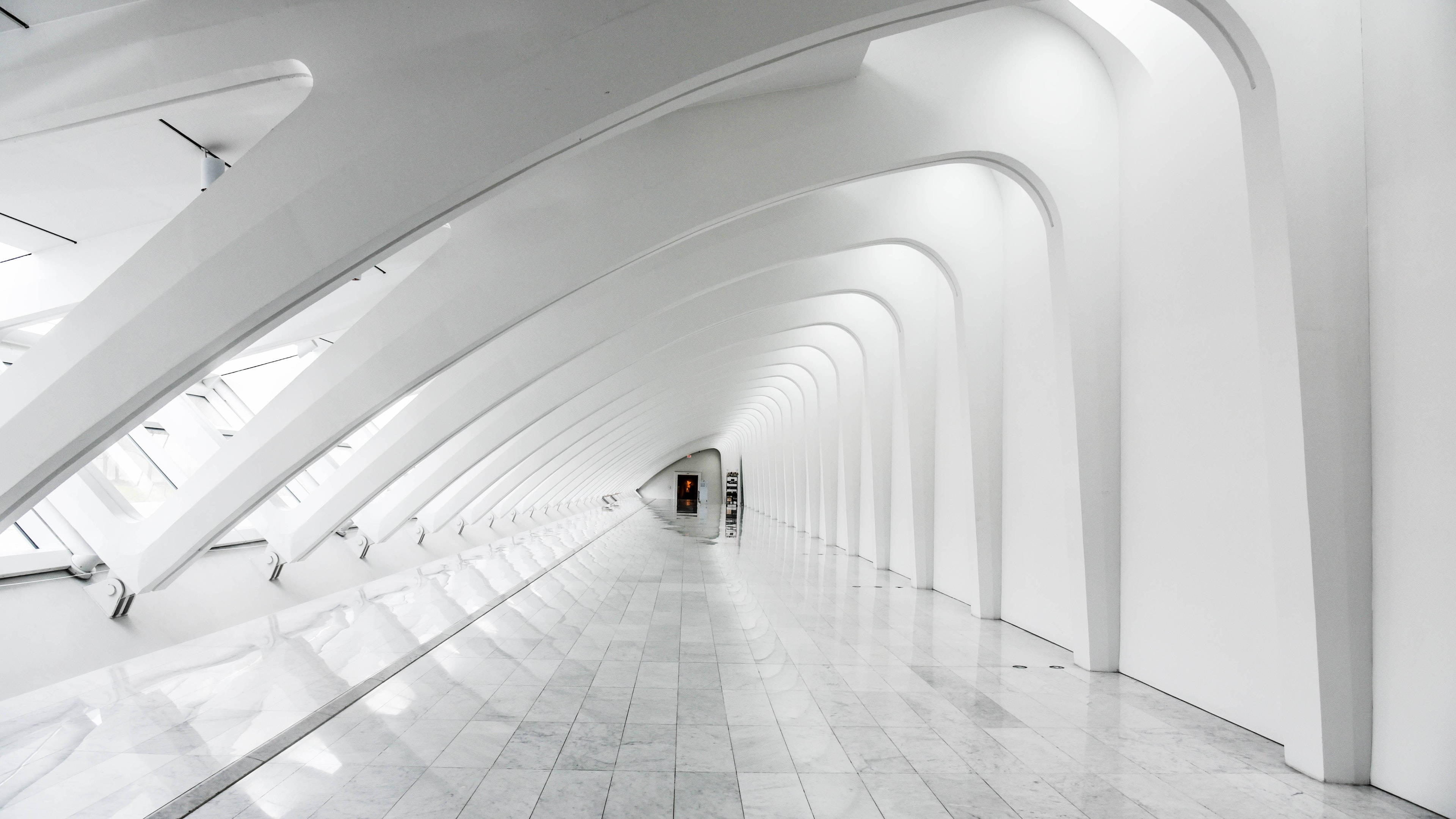 white architectural corridor, repeating curved arches, reflective tiled floors, 4K Desktop Wallpaper