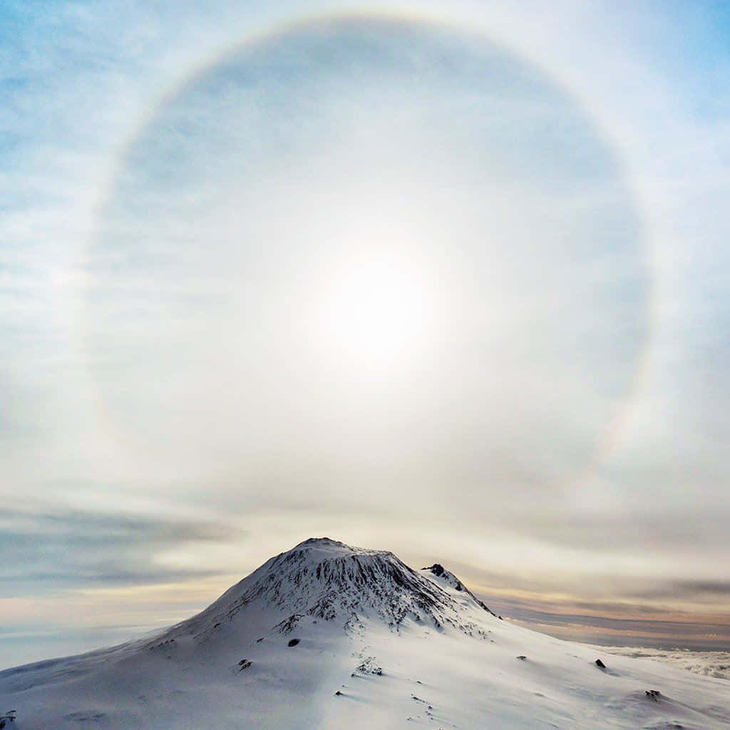 White iPad, snowcapped mountain peak, luminous solar halo, SD Desktop Wallpaper