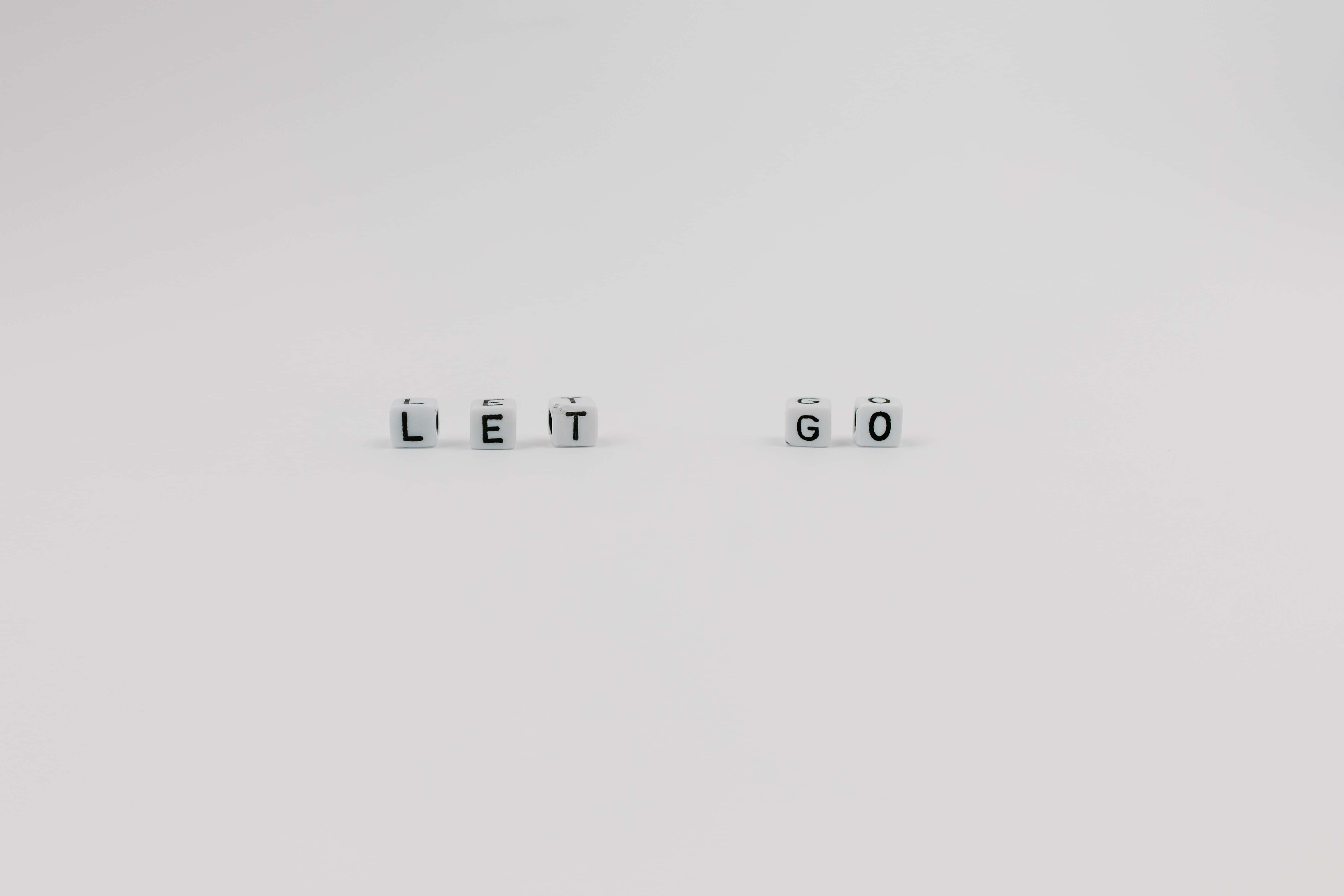LET GO, white lettered cubes, plain white surface, 5K Desktop Wallpaper