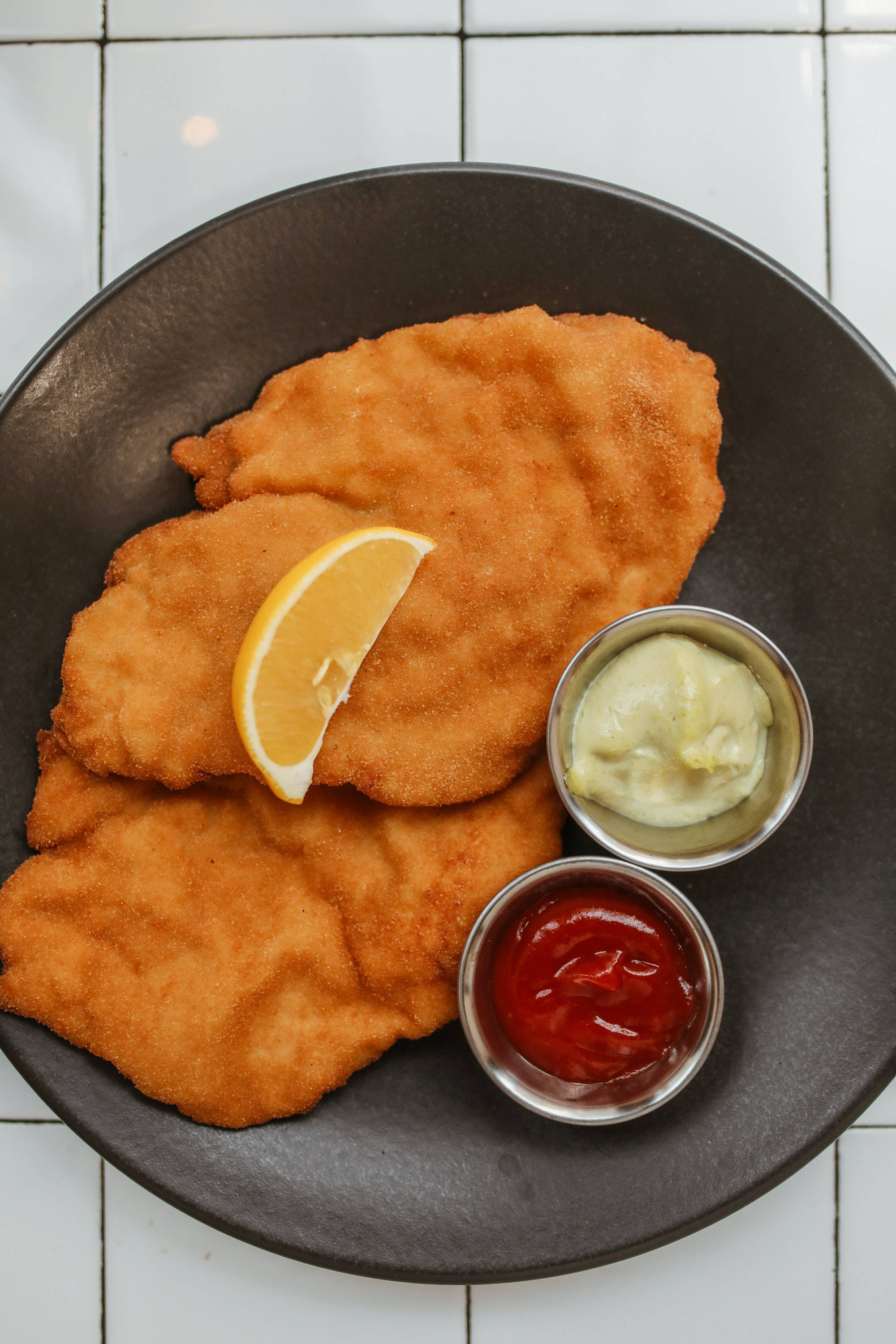 Wiener Schnitzel, golden-brown breaded schnitzel, dark plate, 2K Phone Wallpaper