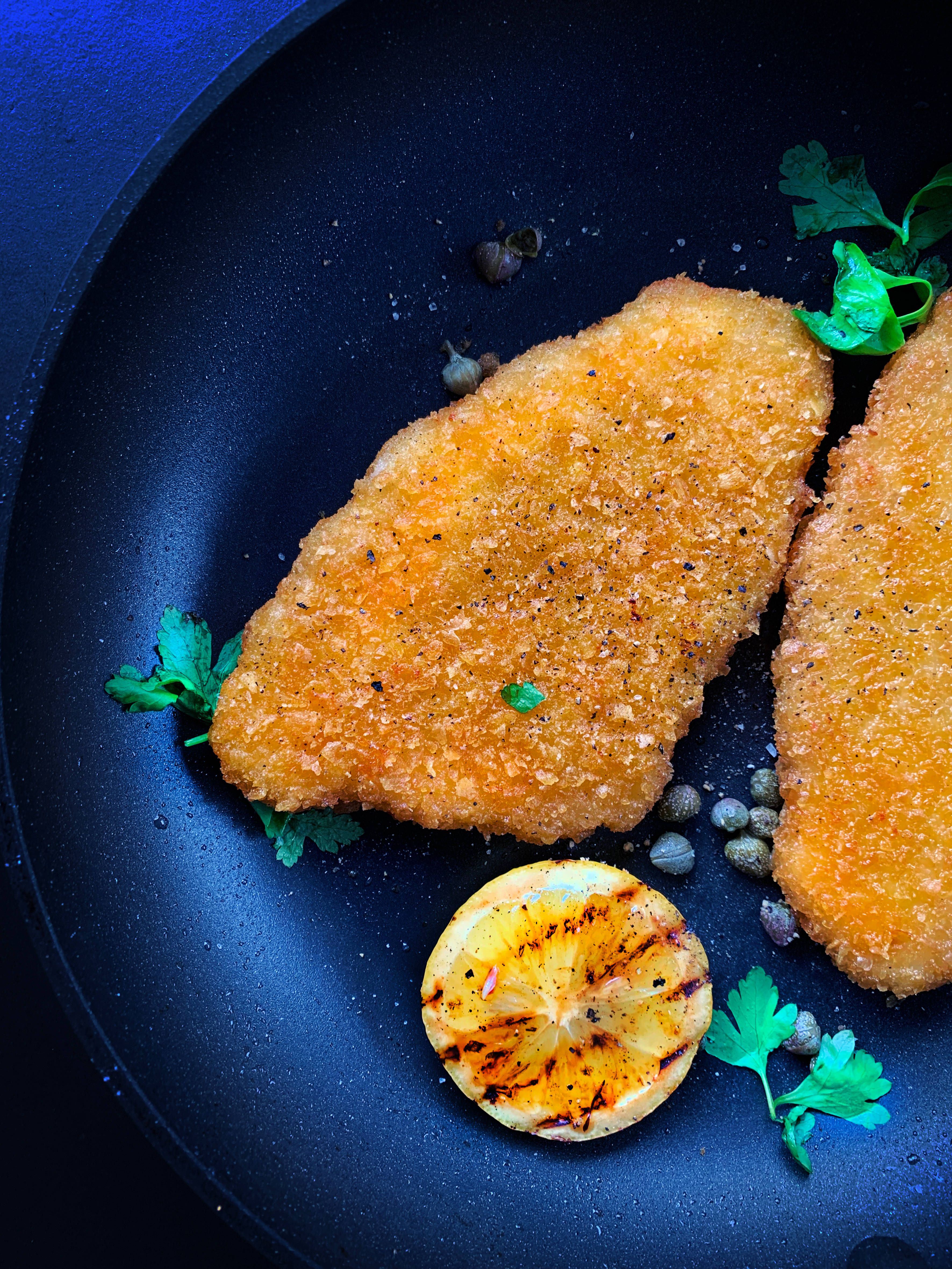 Wiener Schnitzel, golden-brown breaded chicken cutlets, dark pan, 4K Phone Wallpaper