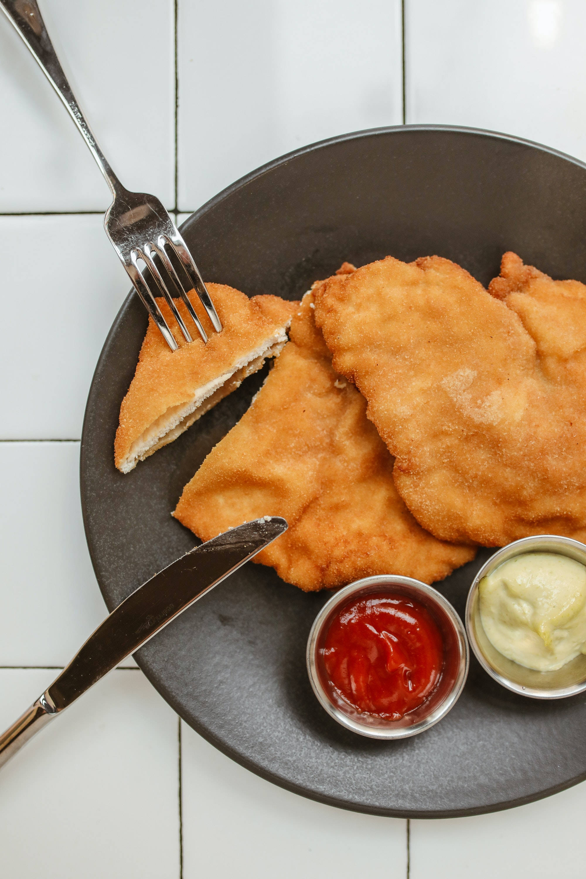 Wiener Schnitzel, golden-brown breaded chicken cutlets, dark plate, 2K Phone Wallpaper