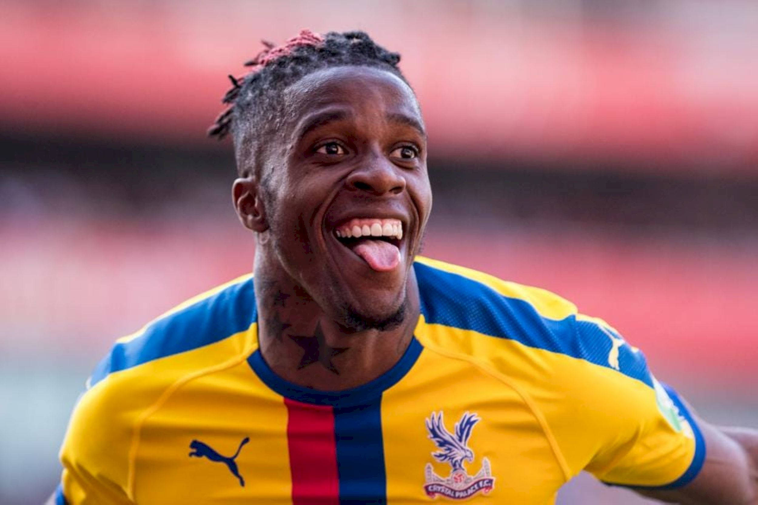 Wilfried Zaha, yellow and blue Crystal Palace jersey, stadium backdrop, Full HD Desktop Wallpaper