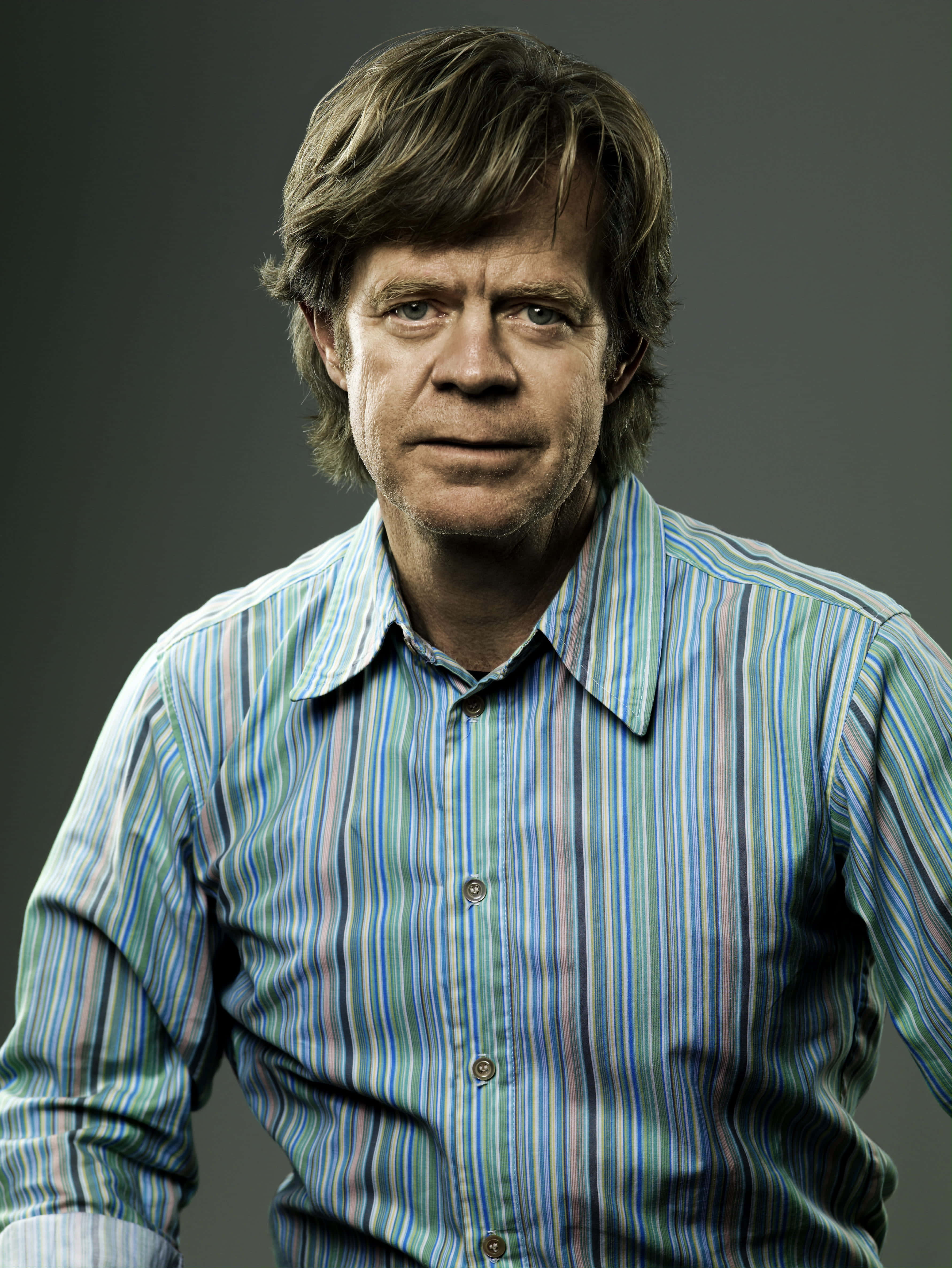 William H. Macy, striped button-up shirt, dark gray studio background, 4K Phone Wallpaper
