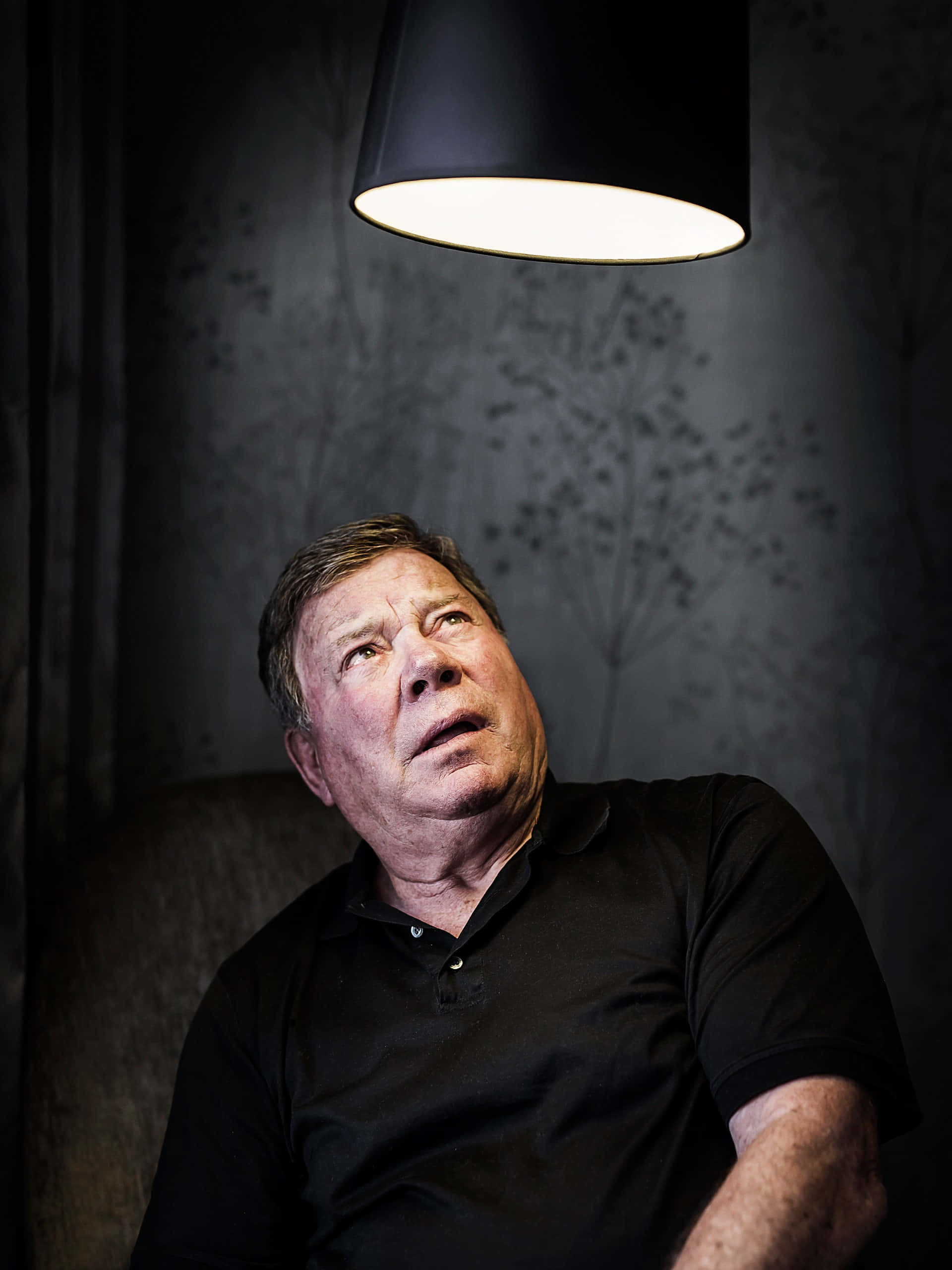 William Shatner, black polo shirt, modern black pendant light, 2K Phone Wallpaper