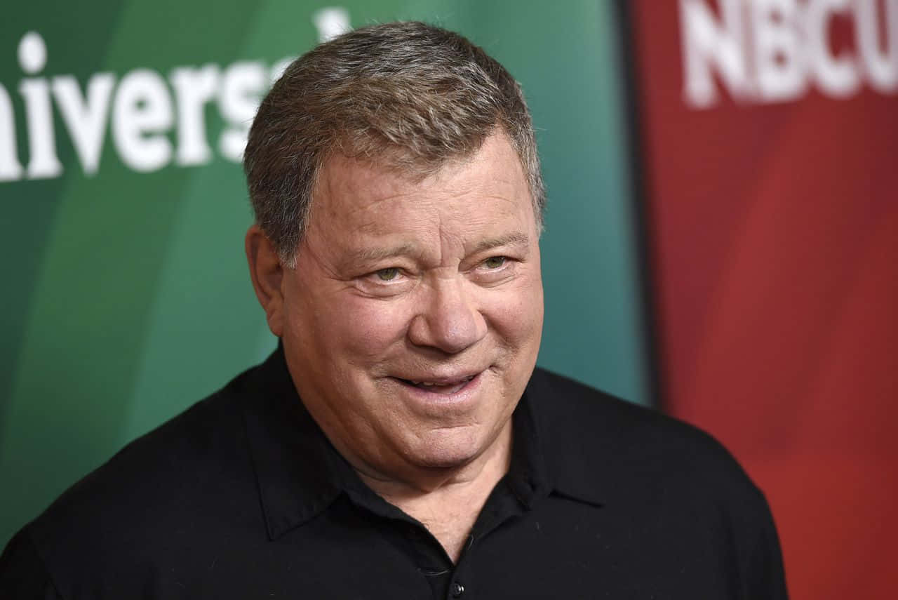 William Shatner, black shirt, green and red branded backdrop, HD Desktop Wallpaper