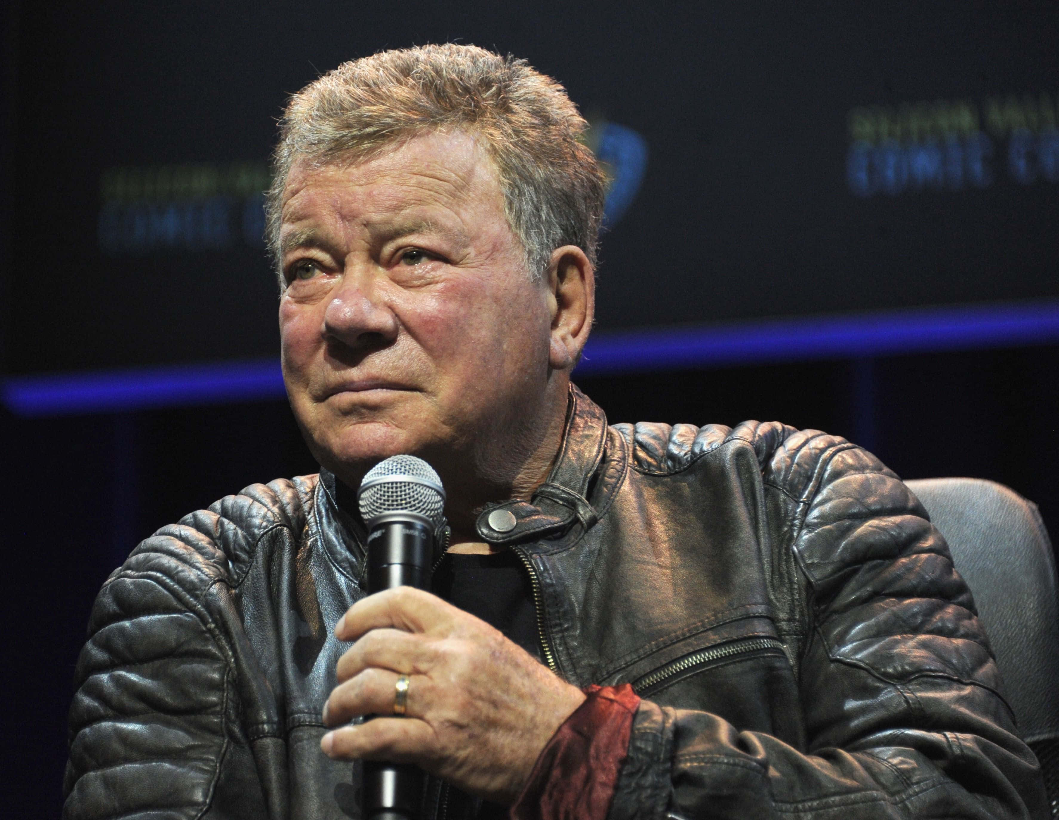 William Shatner, textured leather jacket, microphone, 2K Desktop Wallpaper