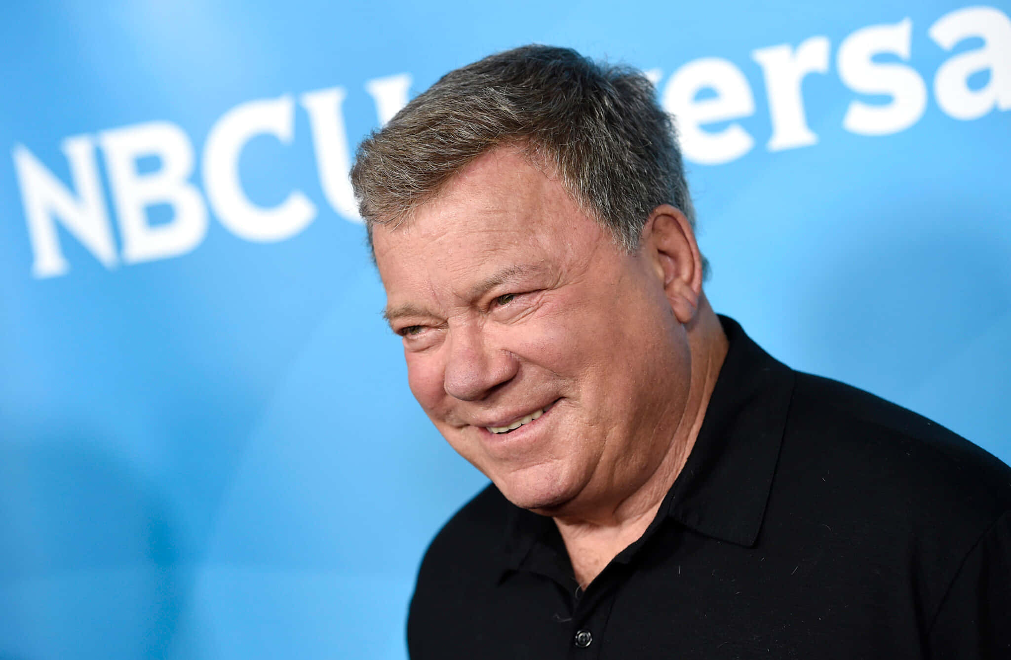 William Shatner, black shirt, blue NBCUniversal backdrop, Full HD Desktop Wallpaper